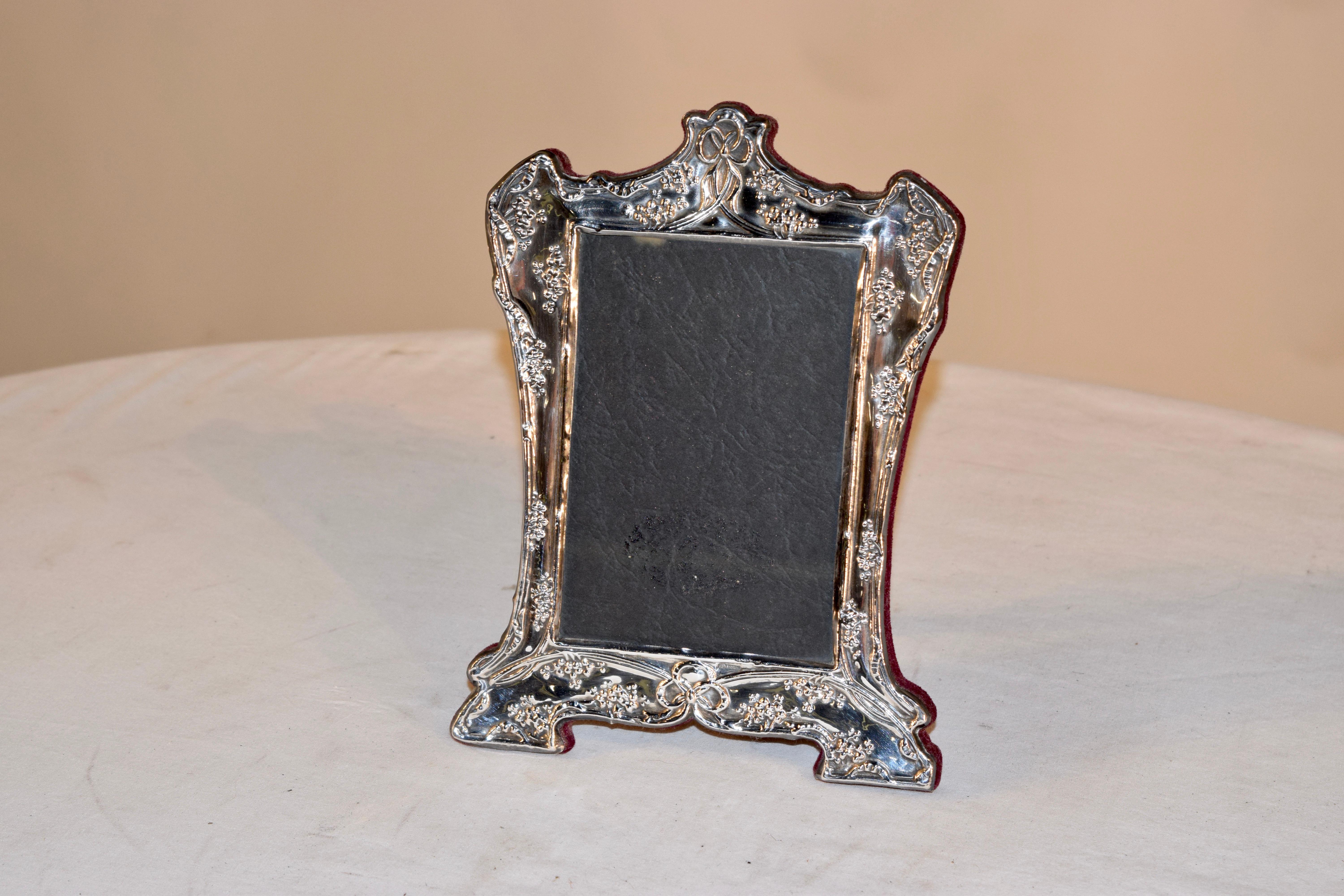 Lovely Art Nouveau picture frame with velvet covered back and stand. The frame has a graceful shape and is decorated with florals. Marked sterling at the bottom of the frame.