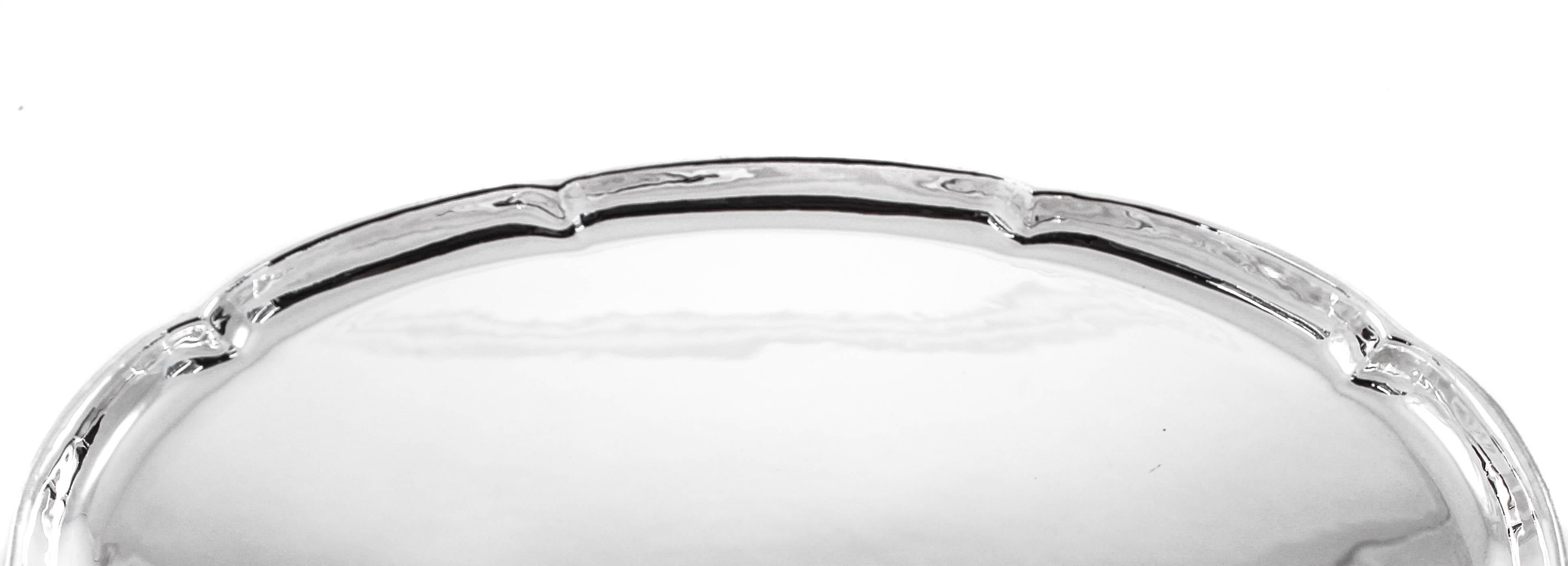 A uniquely designed arts and crafts period hand-wrought sterling silver tray. Simple and yet sophisticated, this piece has a scalloped edge. The interior is completely flat and ideal for serving food or for under candlesticks. Being a period piece