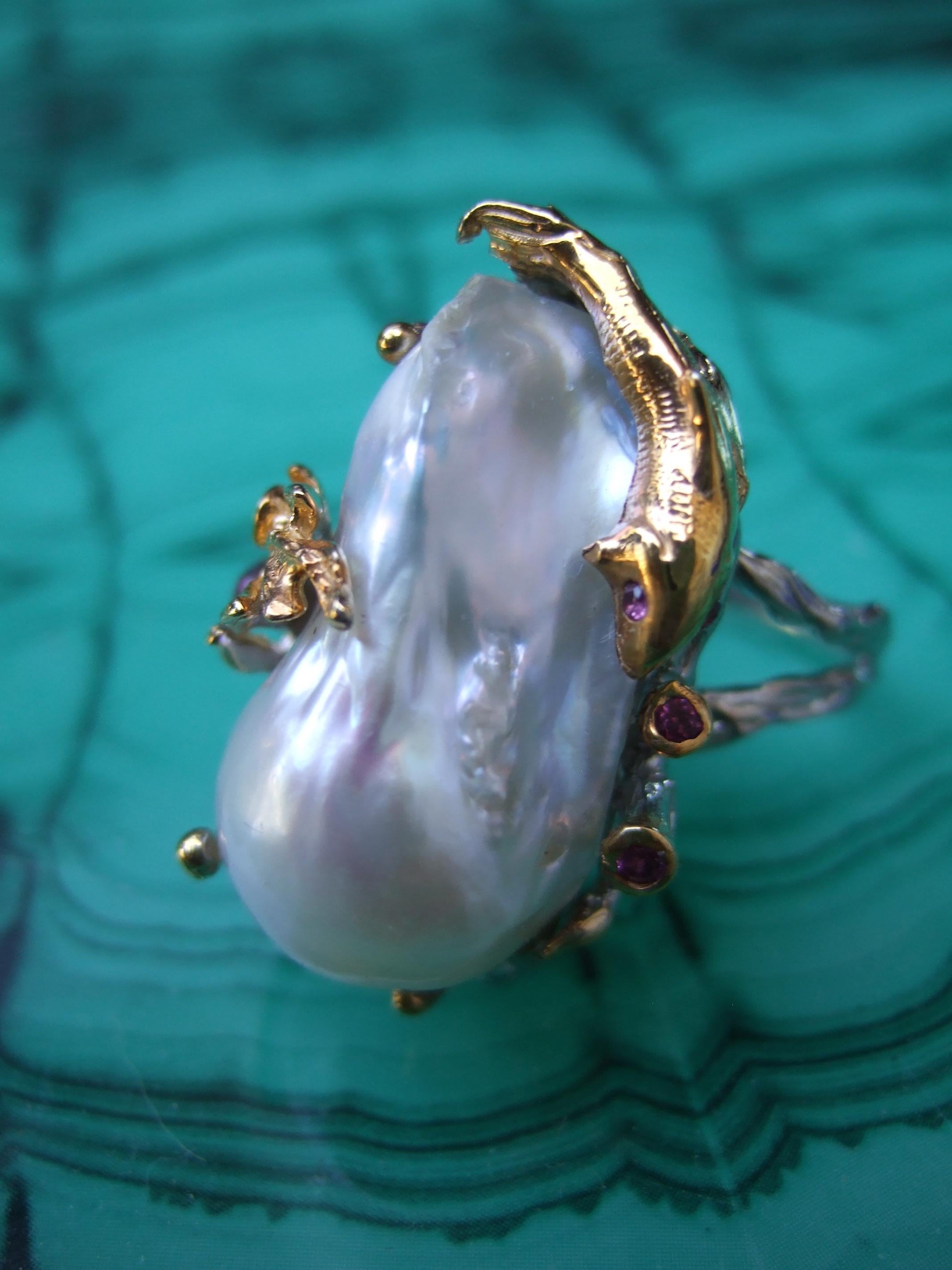 Sterling baroque fresh water pearl artisan ring size 9
The unique artisan ring is adorned with a large scale lustrous baroque
fresh water pearl

The baroque is framed with organic irregular shaped shaped gilt metal prongs
The gilt metal prongs are