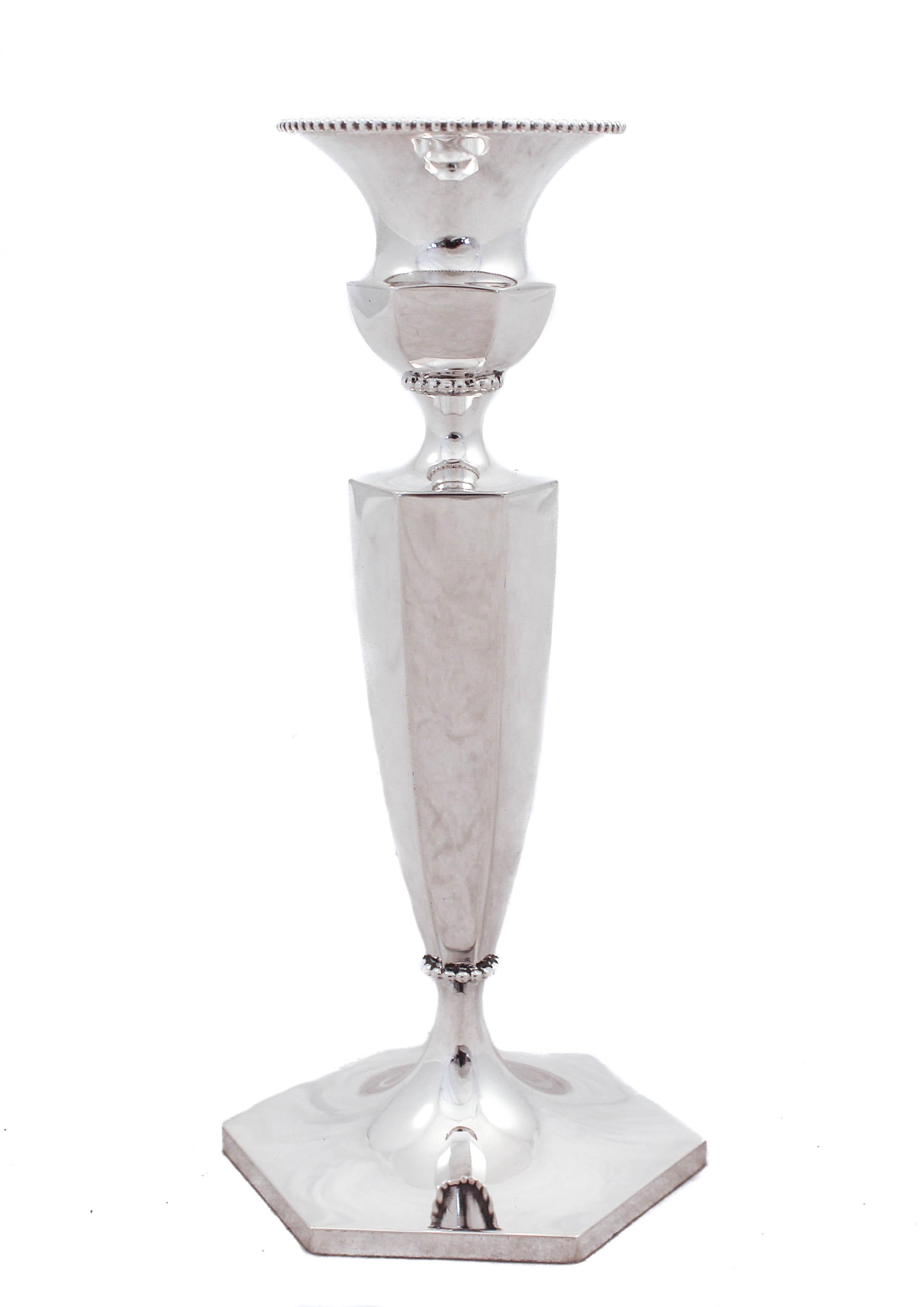 We are happy to offer this pair of sterling silver candlesticks by Shreve, Crump & Low of San Francisco. They have a hexagon shaped top, body and base. Around the bobeche, neck and waist there is a beaded design. They are very elegant and timeless.