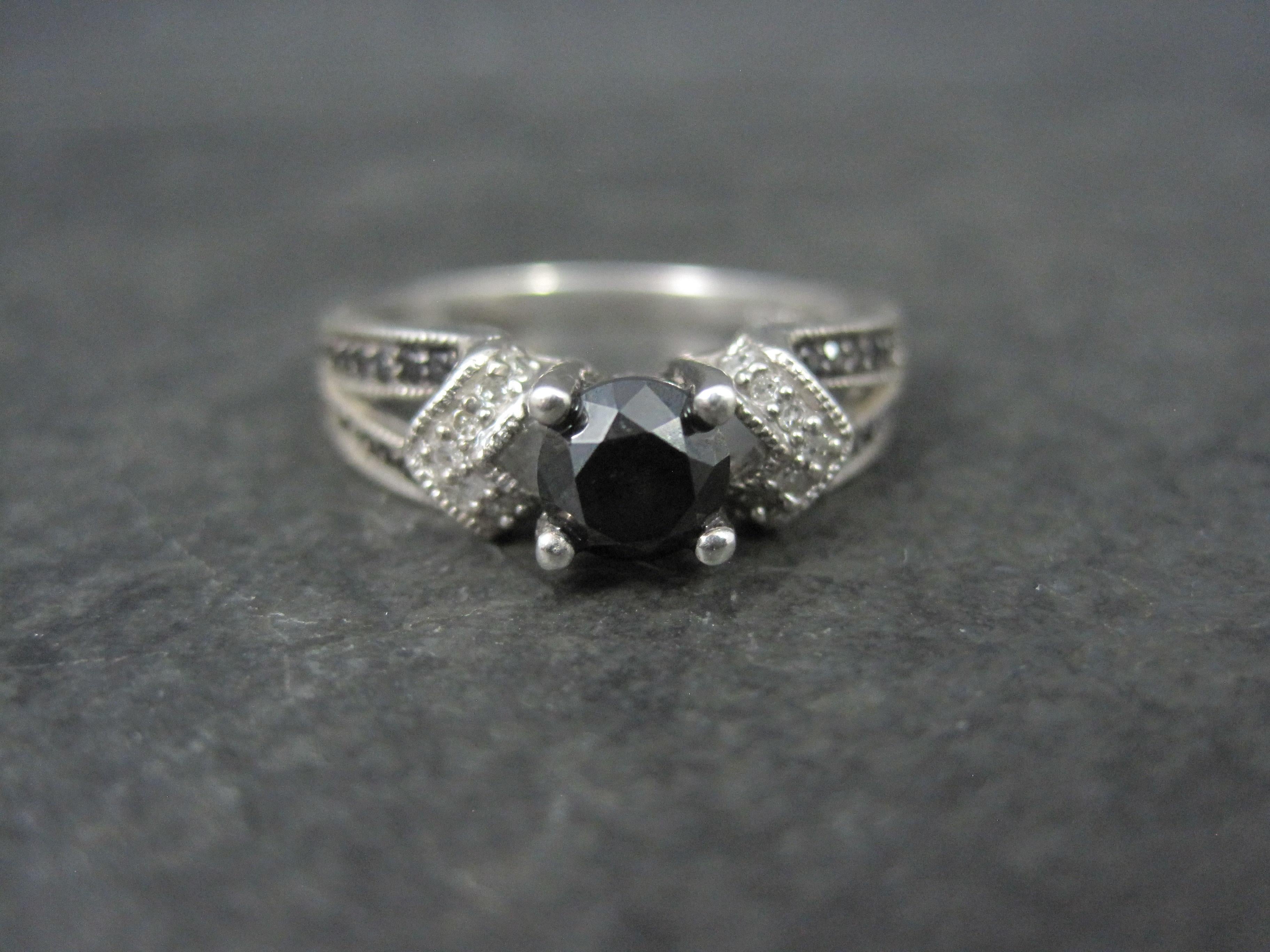 This beautiful engagement ring is sterling silver.
It features a .50 carat, round cut black diamond focal and an estimated .30 carats in black and white diamond accents.

The face of this ring measures 1/4 of an inch north to south with a rise of