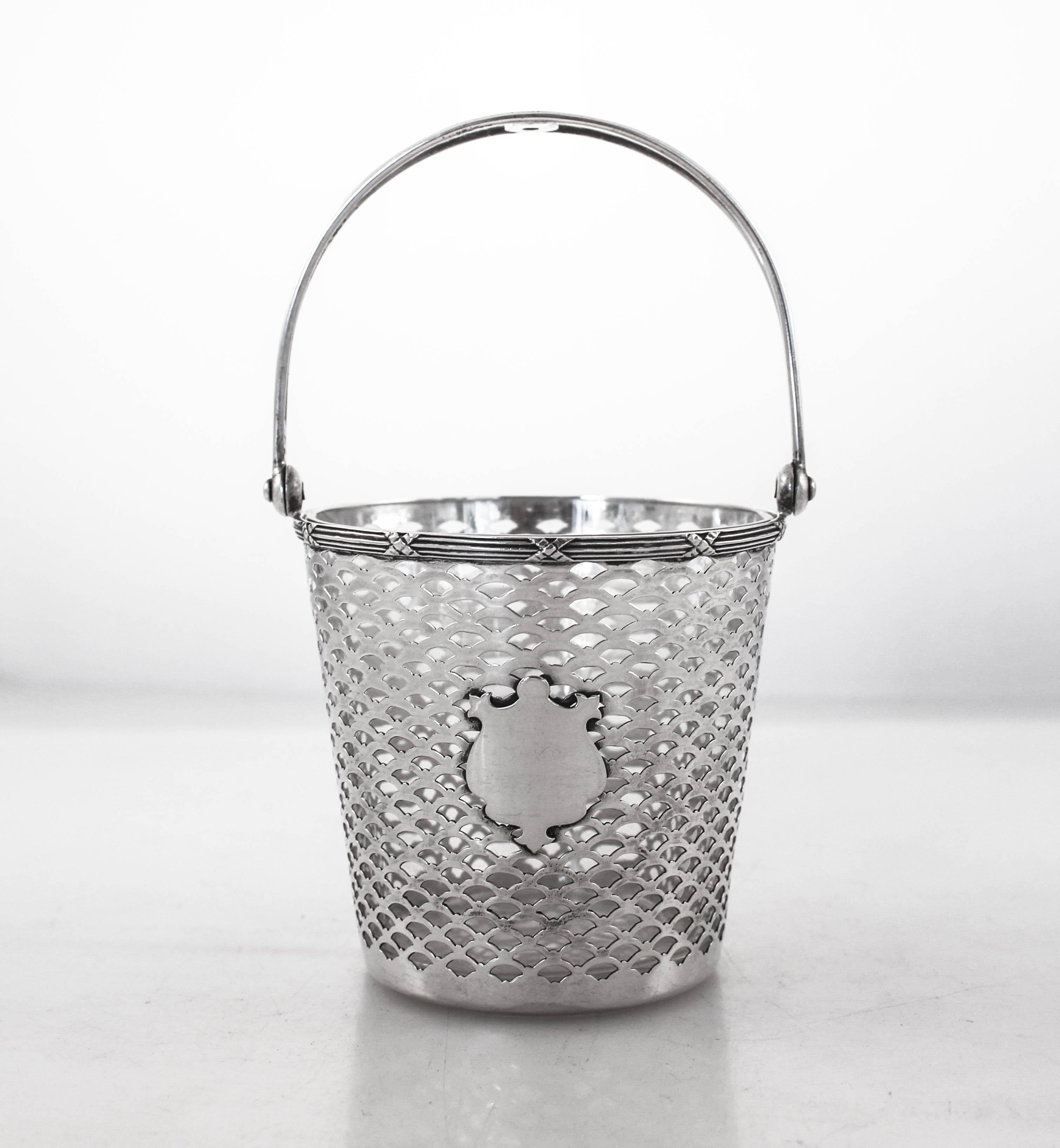 We’re just gaga over this sterling silver bucket with a glass insert. Done in an arts and crafts style it has an open work pattern. In the center a cartouche awaits your monogram. The handle folds up and down for easy storage. The glass insert comes