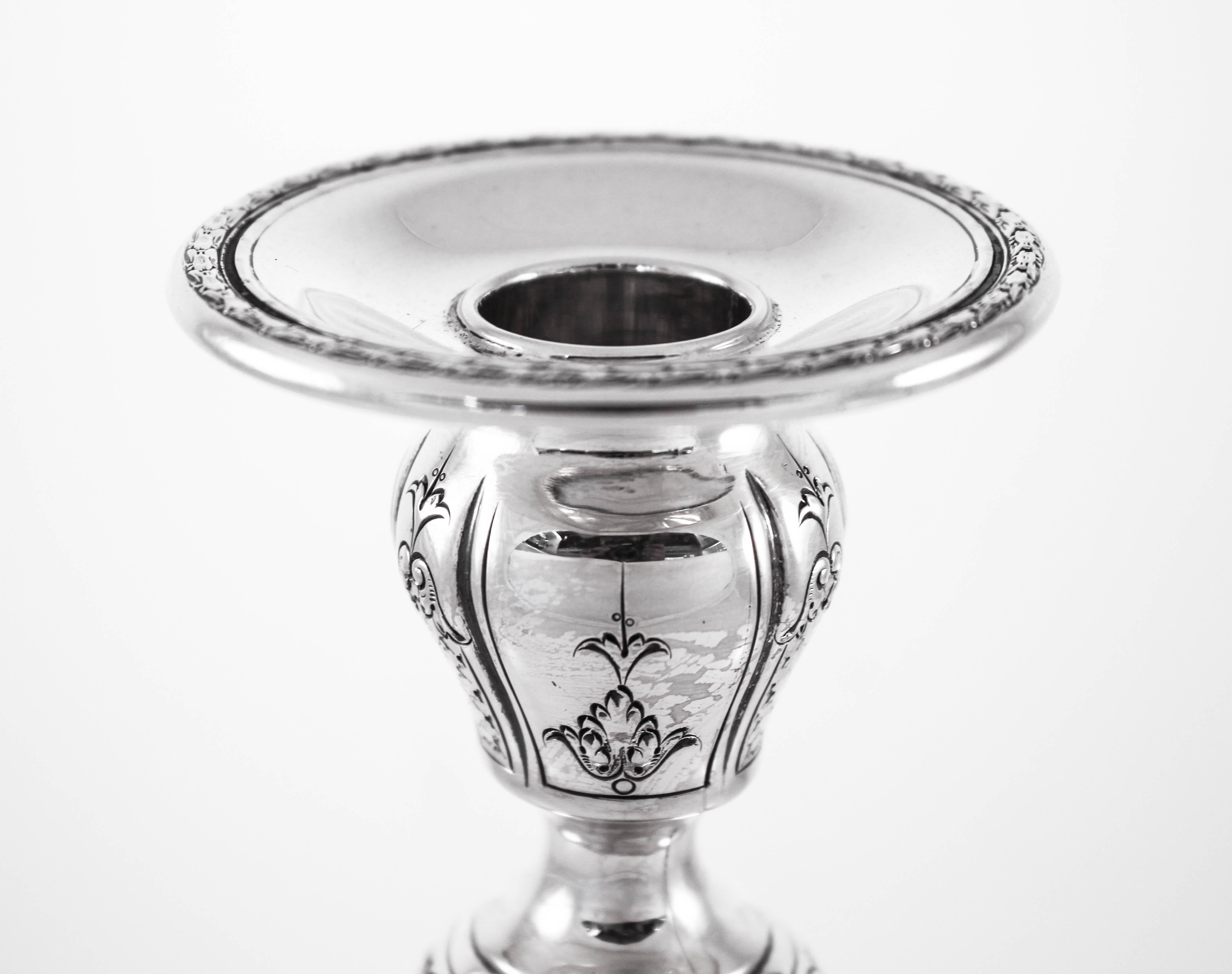 These sterling silver candlesticks have old world charm and grace. There is an etched motif along the base, body and top of flowers, wreaths and scrolls. Even the bobeche has the same pattern as can be found along the base. No detail was overlooked