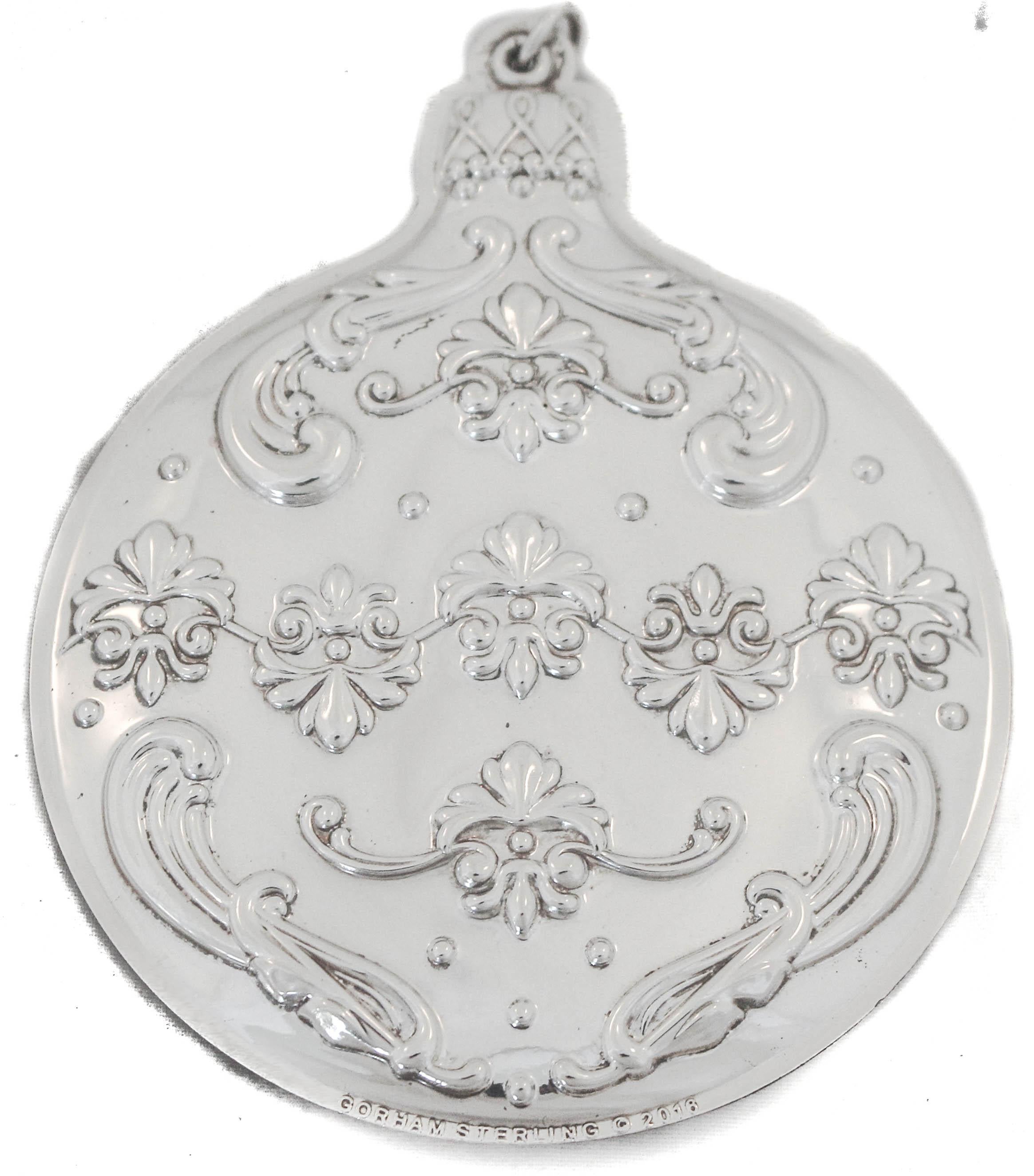 We are thrilled to offer you this sterling silver Christmas ball ornament made by Gorham Silversmiths of Providence, Rhode Island. 
It’s beautifully decorated on both side, so it doesn’t matter which side is showing. It has festive holiday motifs