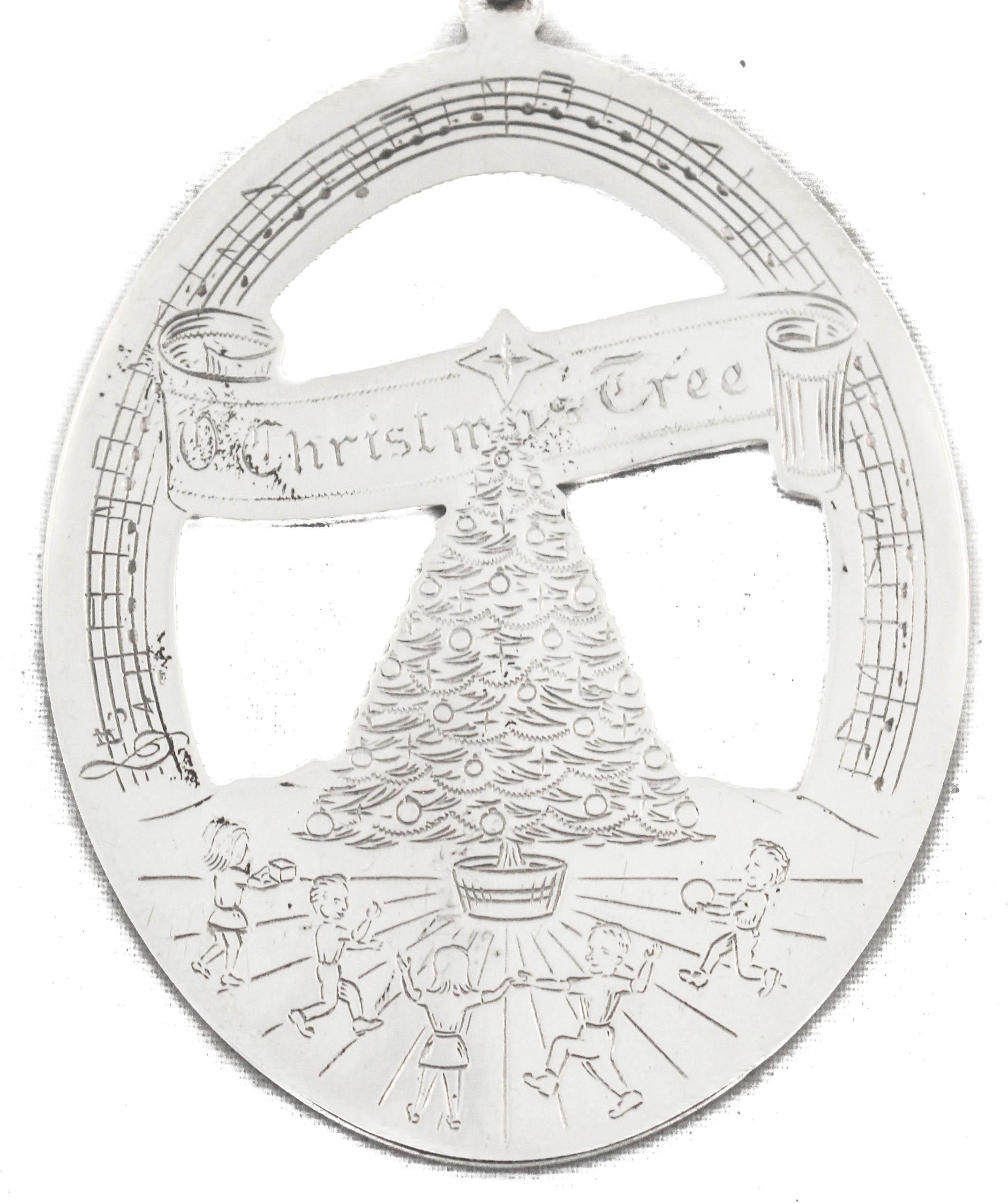 Siamo lieti di offrirti questo ornamento natalizio in argento sterling del 1978 di Lunt Silvermiths. La forma è ovale con un ritaglio al centro. Su un lato, lungo il bordo superiore, c'è scritto 