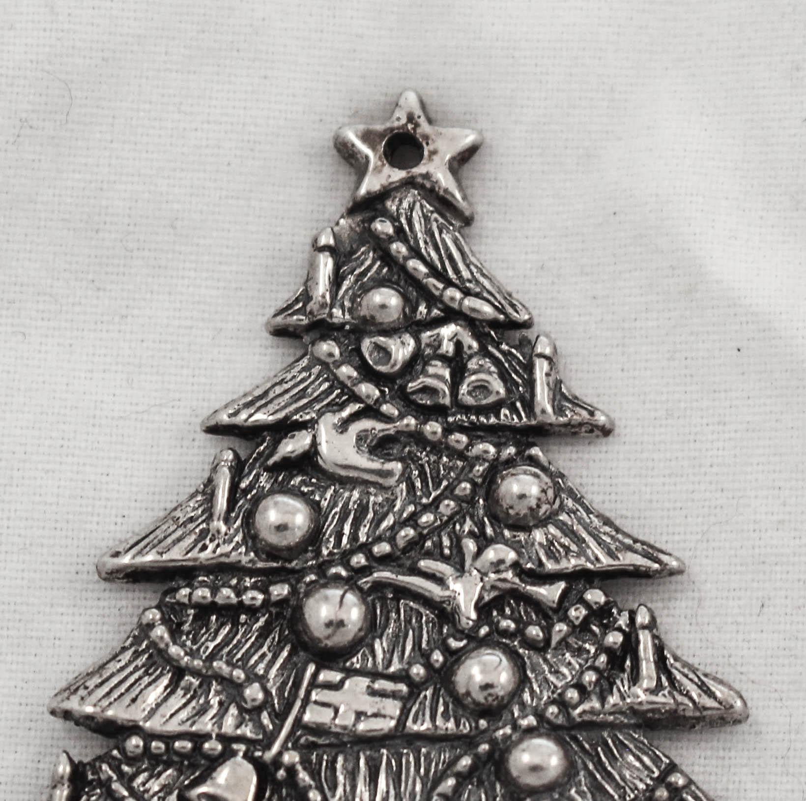 We are thrilled to offer this sterling silver Christmas ornament of a decorated Christmas tree. Bells, baubles, angels with horns, candies and a star give this tree that decorated holiday look. An old and rare sterling Christmas ornament to add to