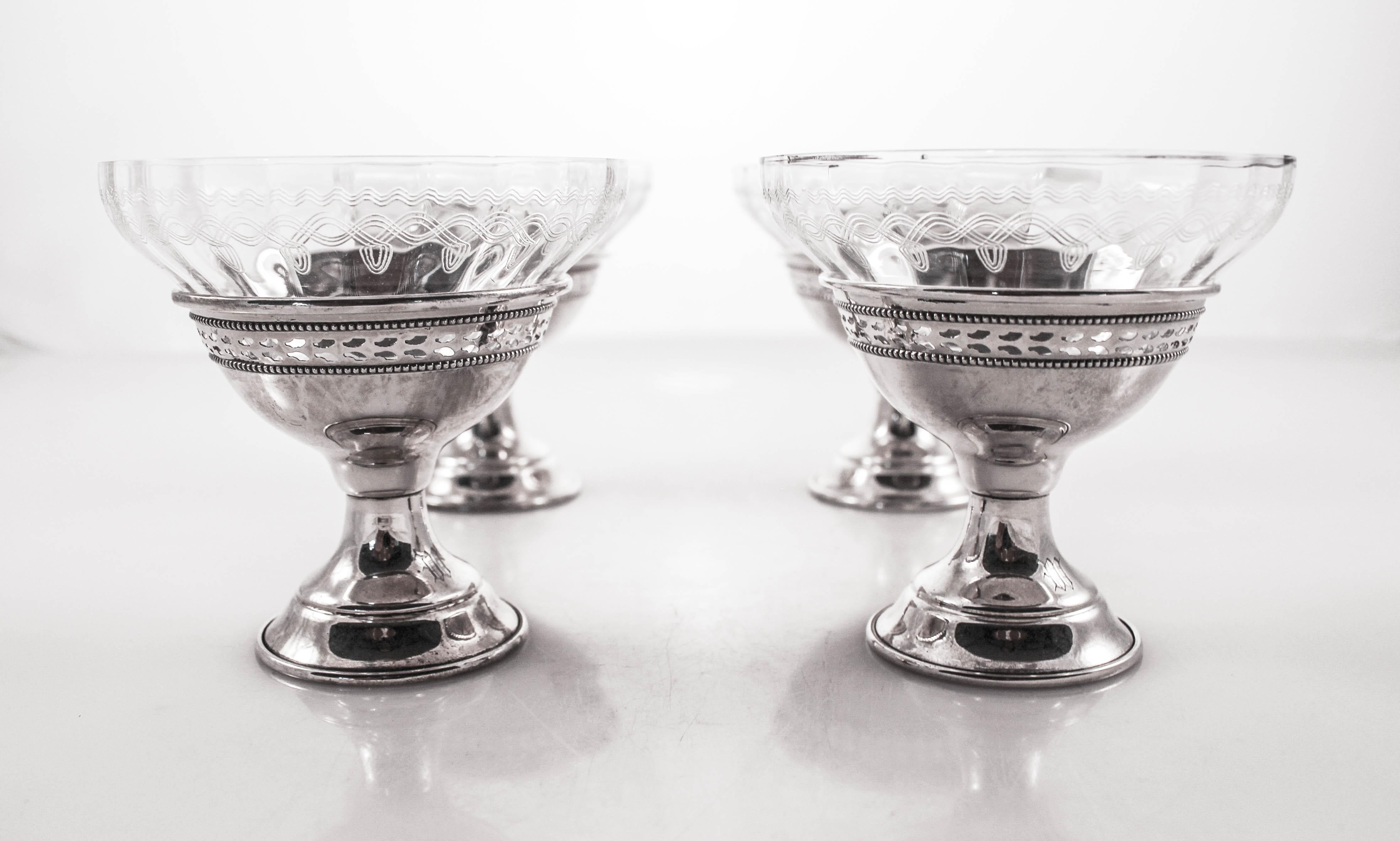 We are offering a set of four sterling silver and crystal dessert cups. Each sterling base is not weighted and has a cutout motif going around the top. Each crystal insert has an acid etched design and fits perfectly into the center. They are in