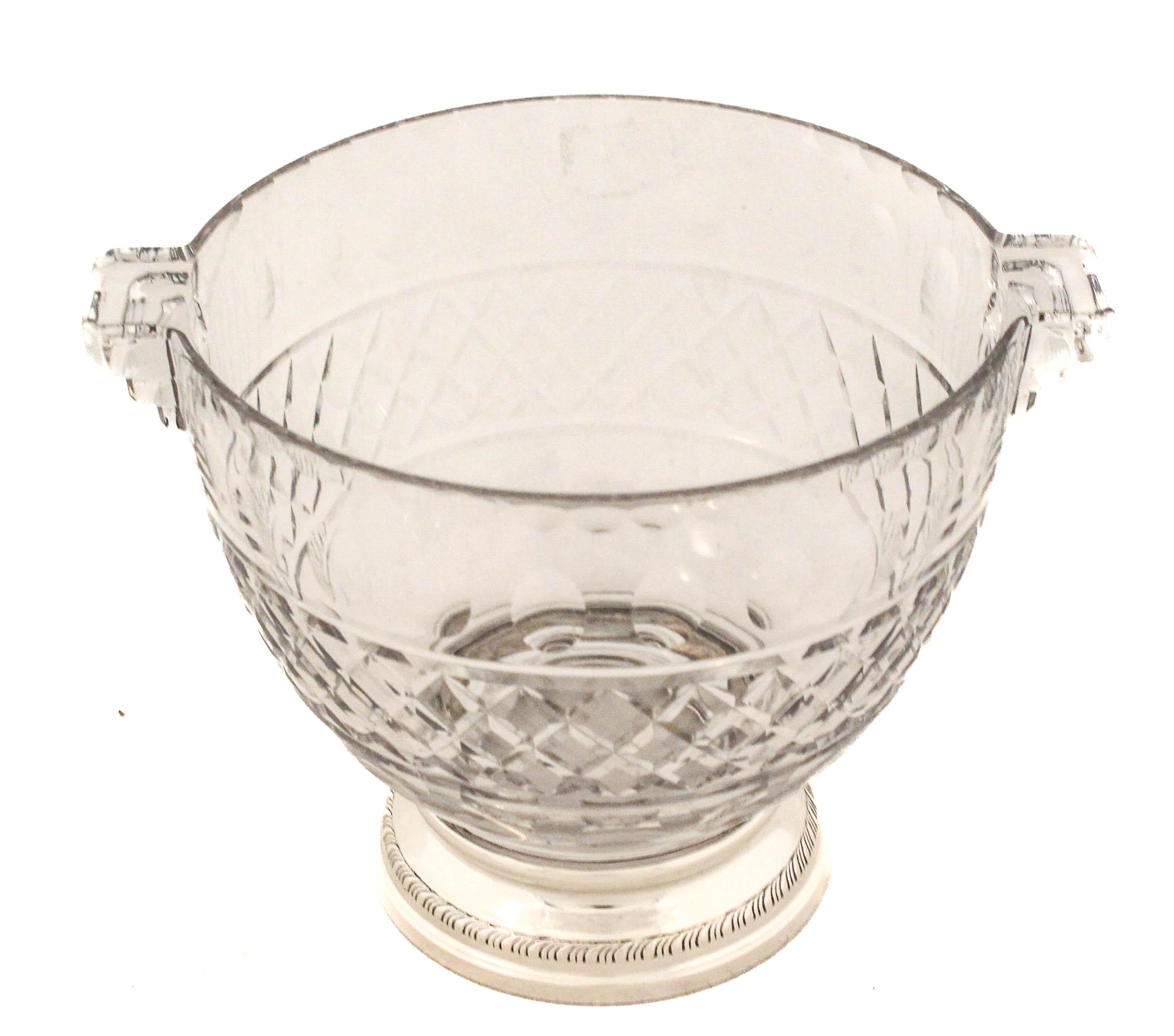 Se ofrece una cubitera de plata de ley y cristal de Shreve & Company de San Francisco.  La parte de cristal tiene diseños simétricos; hendiduras ovaladas alrededor de la parte superior y una piña en forma de diamante alrededor del centro.  Tiene