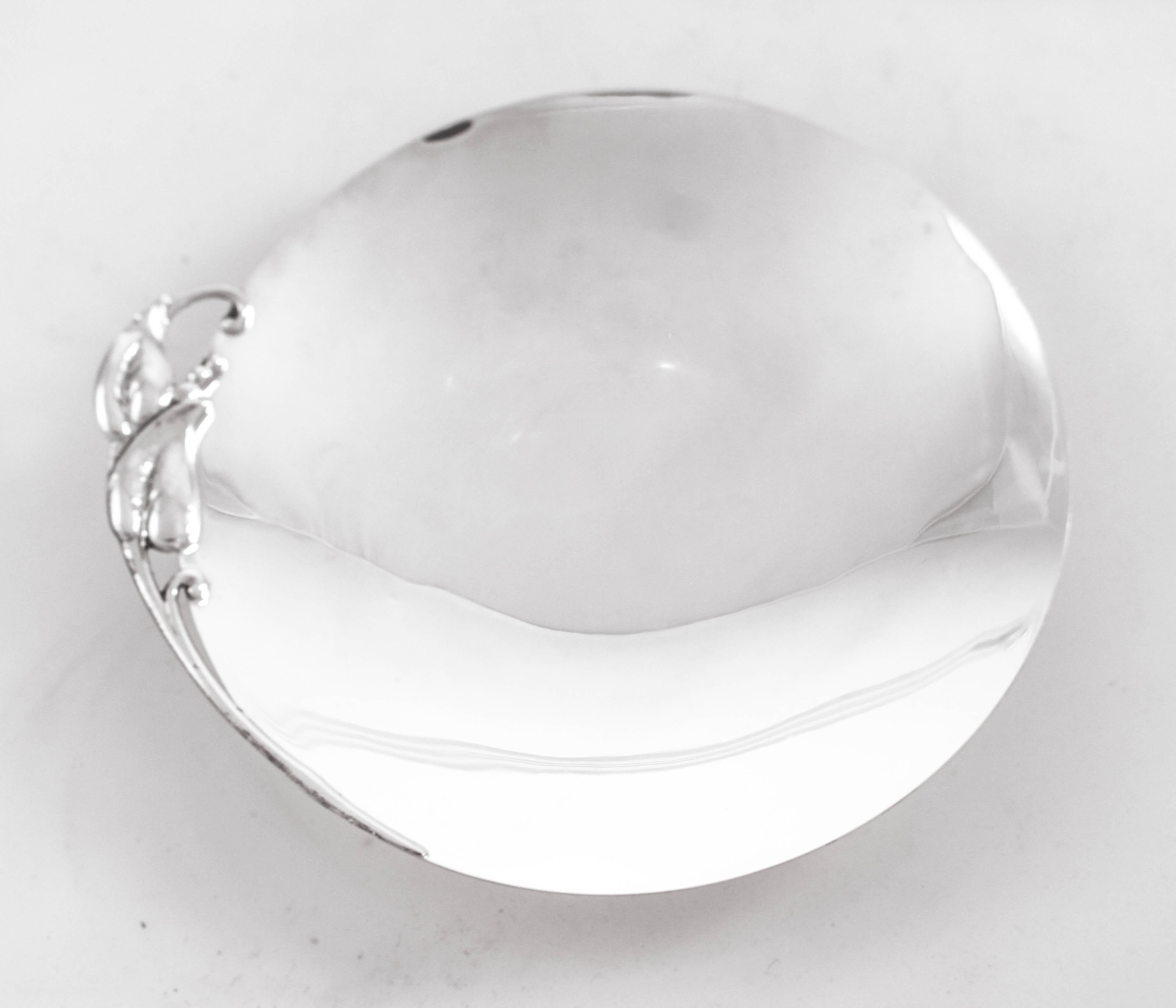 We are proud to offer this sterling silver midcentury dish by Reed and Barton. Signed on the back with the 1946 hallmark, it was manufactured at the beginning of the Mid-Century Modern period. It is a sleek piece with just a Jensen-esque handle on