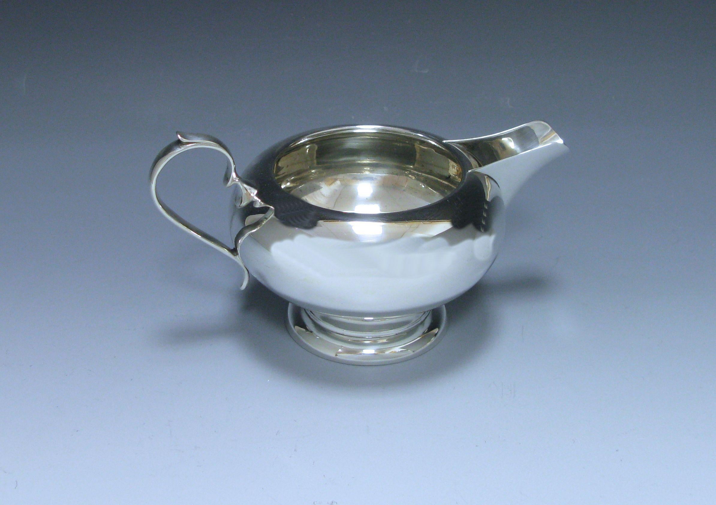 A stylish sterling George V silver four-piece tea and coffee service which is of plain unembellished baluster form. The teapot and coffee pot both have wooden handles and finials. By Charles Green & Co. Birmingham 1929-1930. 

Measures: Height of