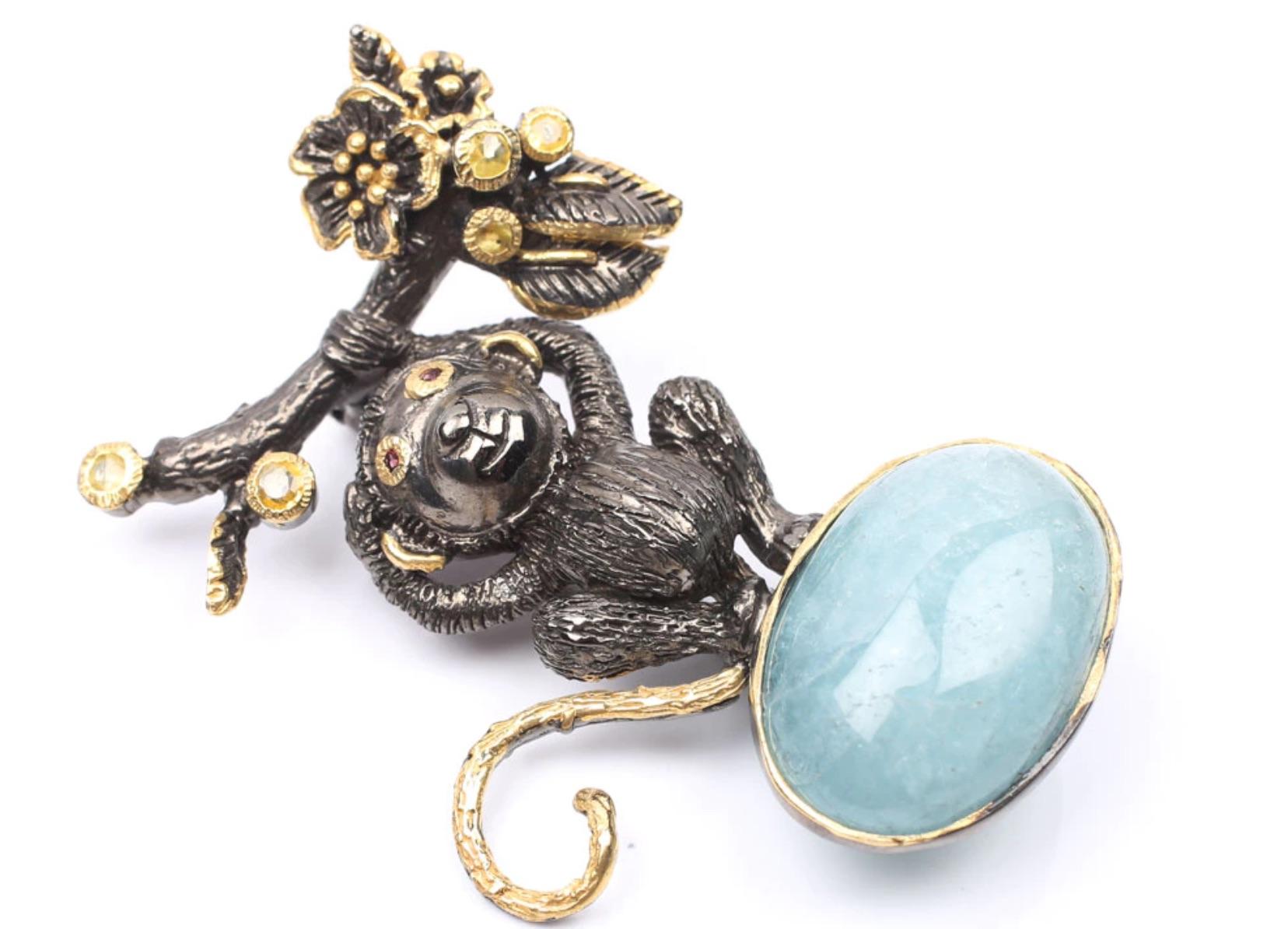 Most Adorable Sterling Silver Oxidized and Polished with Vermeil touches
Monkey Brooch featuring 22.82 ct. Aquamarine Cabochon Gemstone and other Gemstones- Sapphires in round vermeil setting, and garnet eyes. Monkey is Hanging from a Flowery Tree