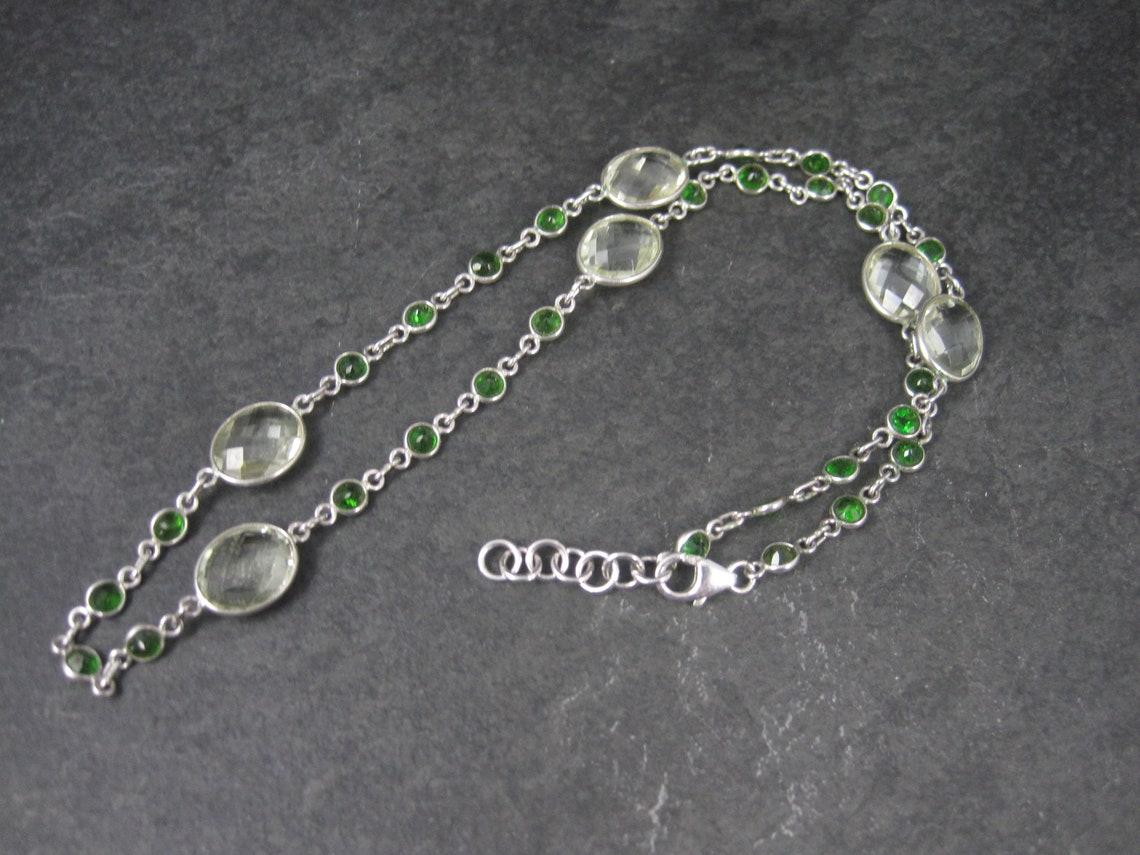 This beautiful necklace is sterling silver.
It features an estimated 18 carats in green amethyst and 2.8 carats in chrome diopside.

It is adjustable from 17.5 to 18.5 inches.

Marks: 925

Condition: Excellent