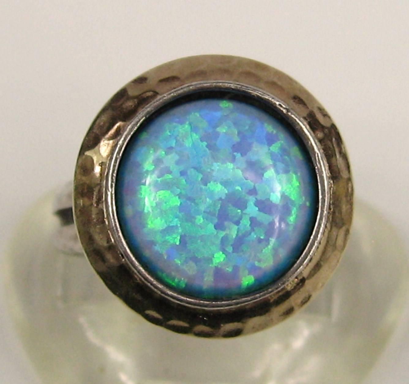 The colors in the opal are fabulous Bezel set in 14K Gold and set in a sterling silver ring Table of ring measures .66 in diameter and stands .55 high Size 6.5  and can be sized by your jeweler or ours. This is out of a massive collection of Hopi,