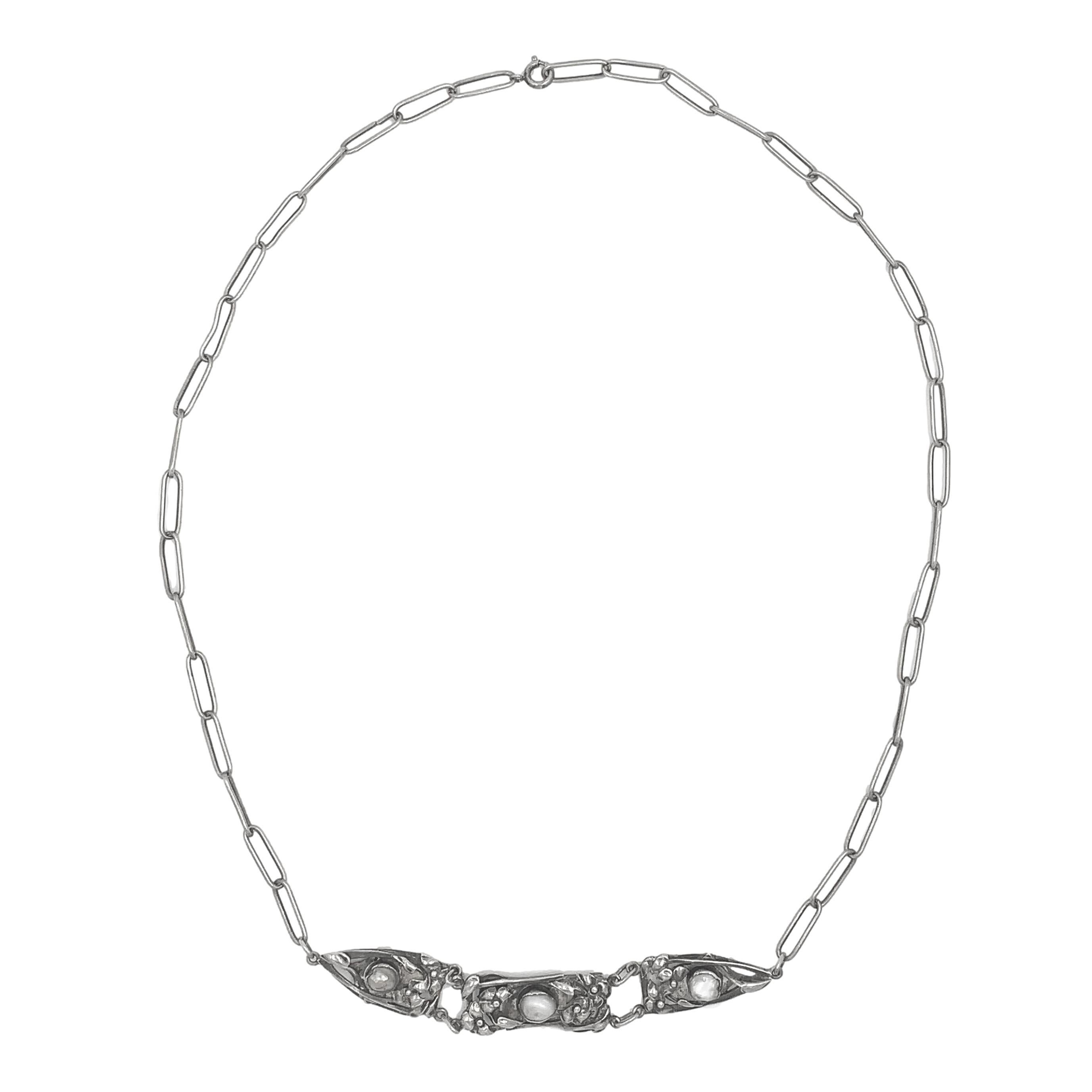 Collana in sterling lavorata a mano realizzata dal negozio d'argento Kalo in Illinois. Marcato Sterling Kalo. La collana presenta 3 pannelli allungati, ciascuno con una perla naturale barocca accentuata da foglie e fiori applicati. Le perle sono