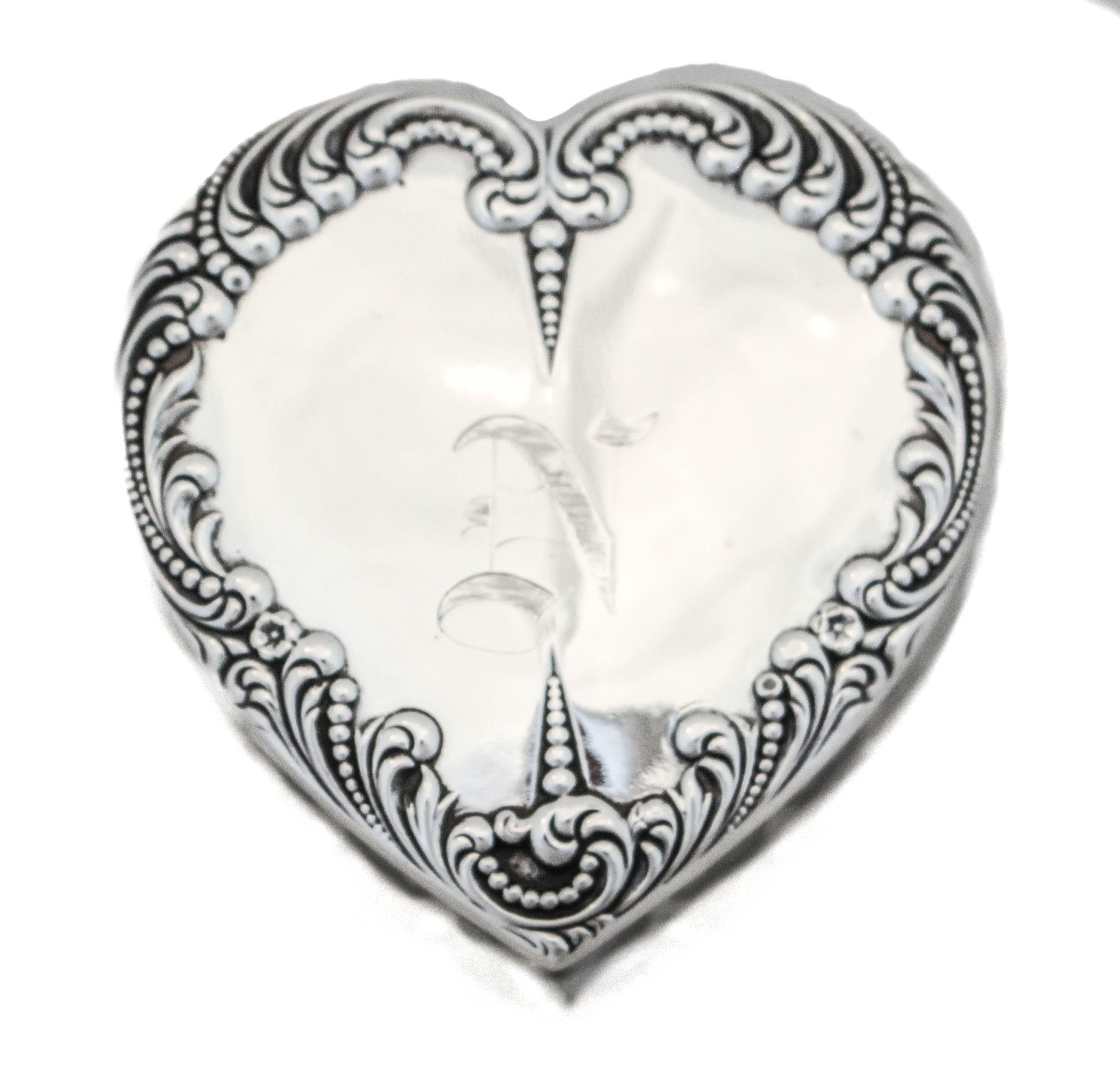We are happy to offer you this sterling silver and crystal heart shaped box. The lid is sterling silver and has fancy raised work around the edge with a hand engraved Old English “N” in the center. The box is cut-crystal with grooves in between each