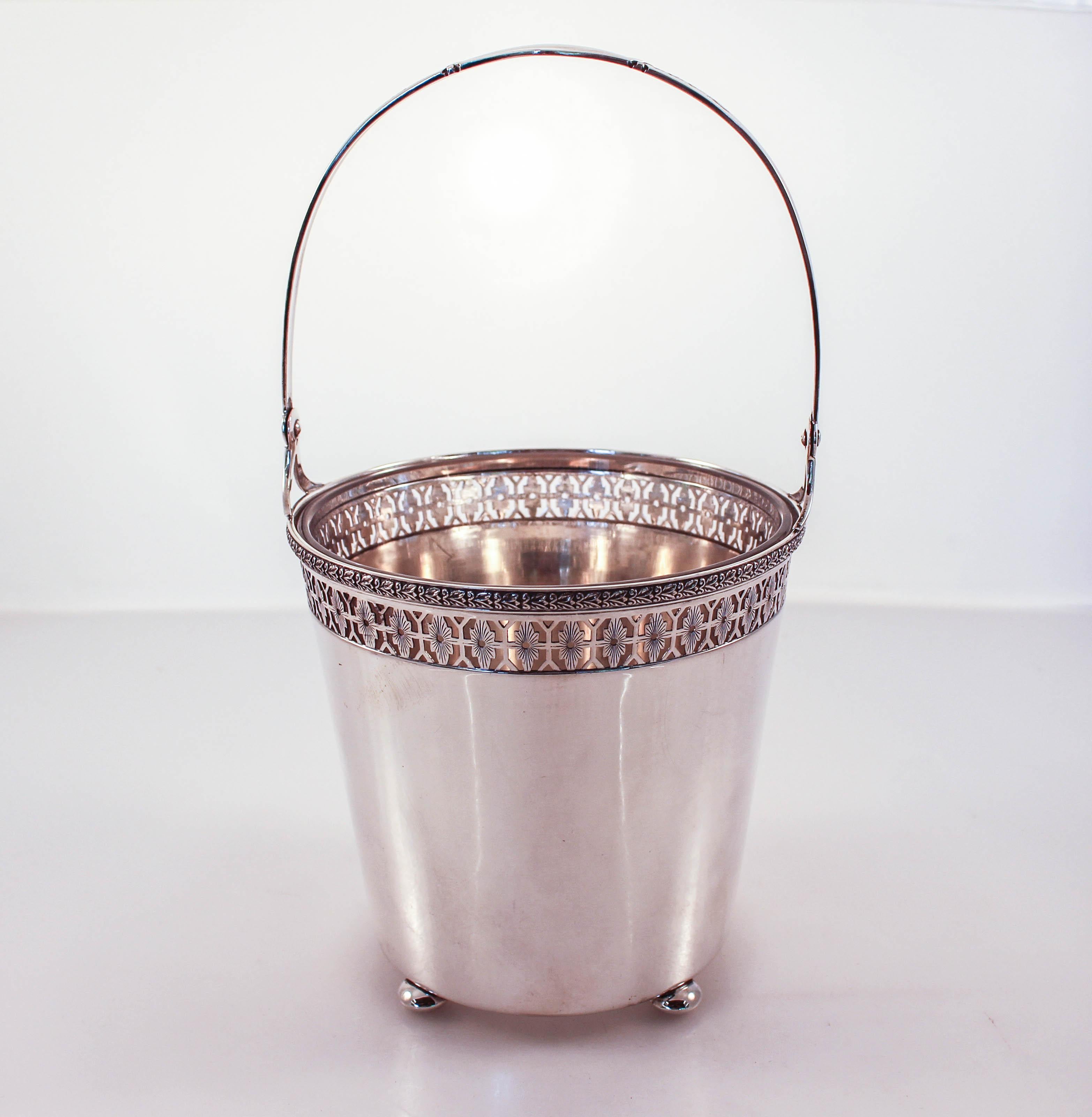 We are proud to offer this sterling silver ice bucket and tongs. The original glass liner with a starburst sits inside the silver bucket. It is removable, which makes it super easy to fill, refill and wash. The ice bucket stands on four balls and