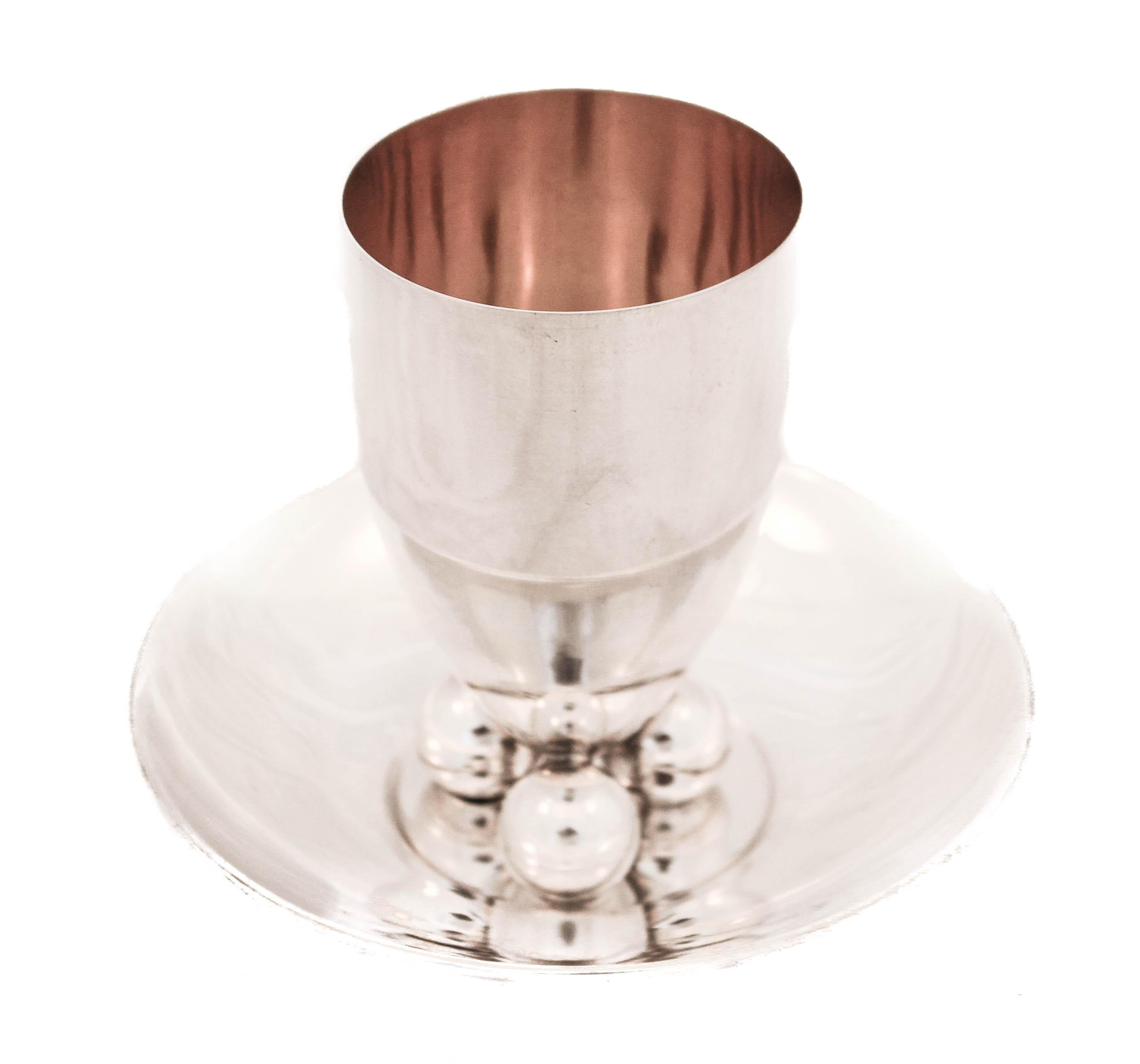 If you love modern, edgy sterling silver, keep reading. This sterling silver cup and plate have a modern “Jensenesque” quality. The cup is sleek and stands on three balls. The plate is flat in the center but curves up around the edge, also standing