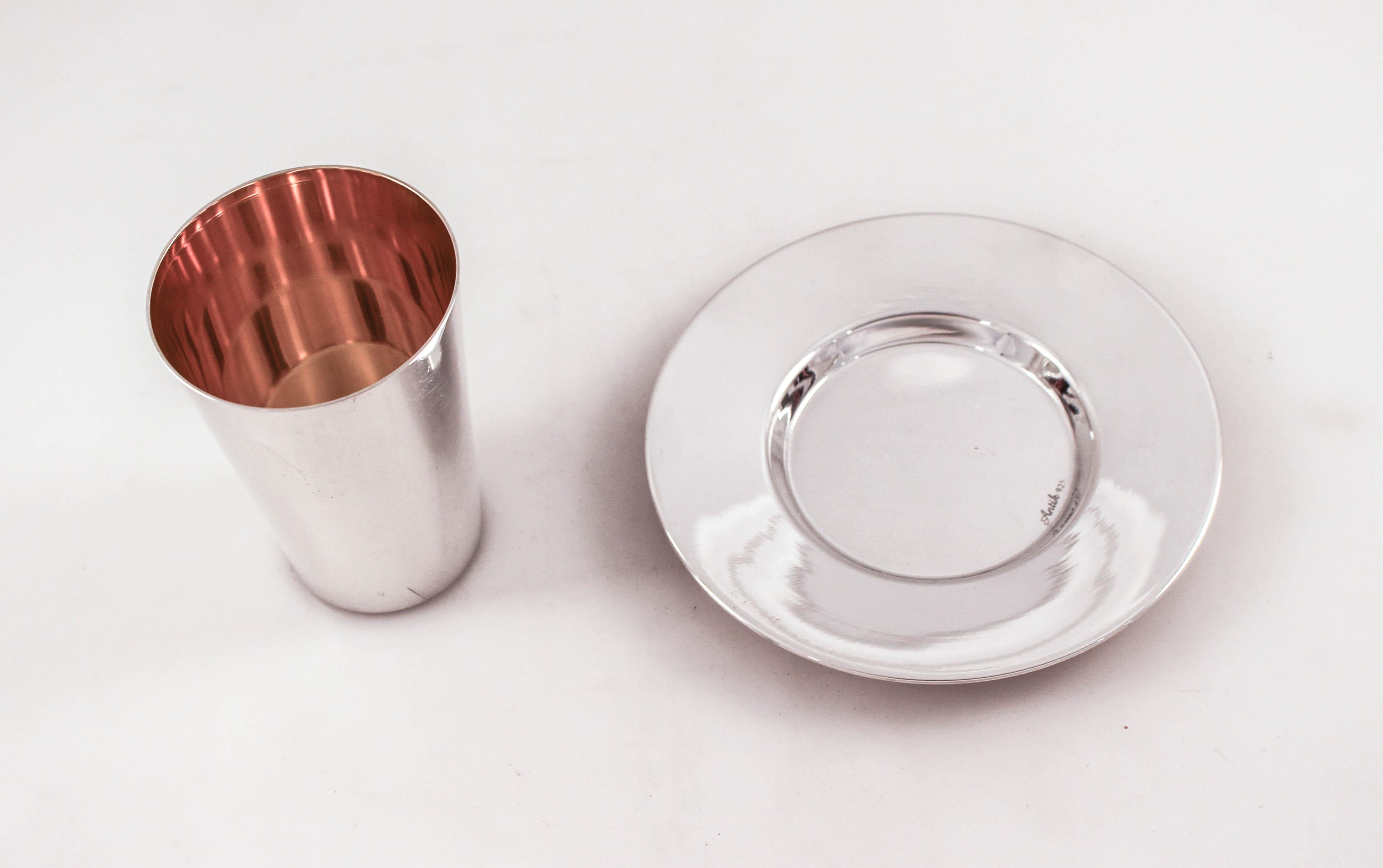 An Uber modern sterling silver Kiddush cup and matching plate. The set is sleek, without all the etchings and casting usually found on Judaica. So go ahead and carry on those thousand year old traditions but do it in a modern cup and plate.