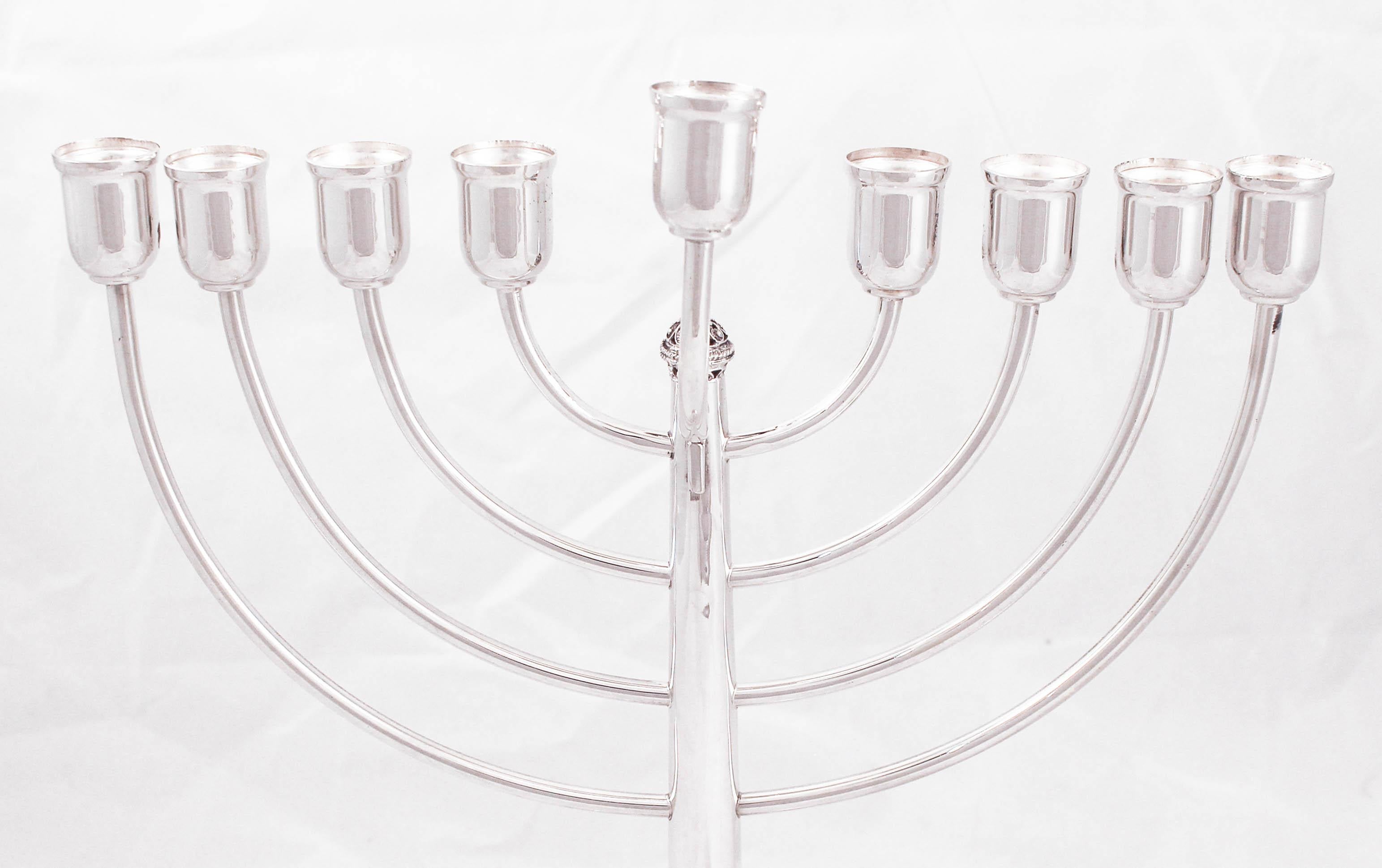 Nous sommes ravis de vous proposer cette ménorah en argent sterling fabriquée en Israël. La fête des lumières, comme on l'appelle souvent à Hanoukka, est commentée par l'allumage de la ménorah à chacune des huit nuits de la fête. Quelle belle façon