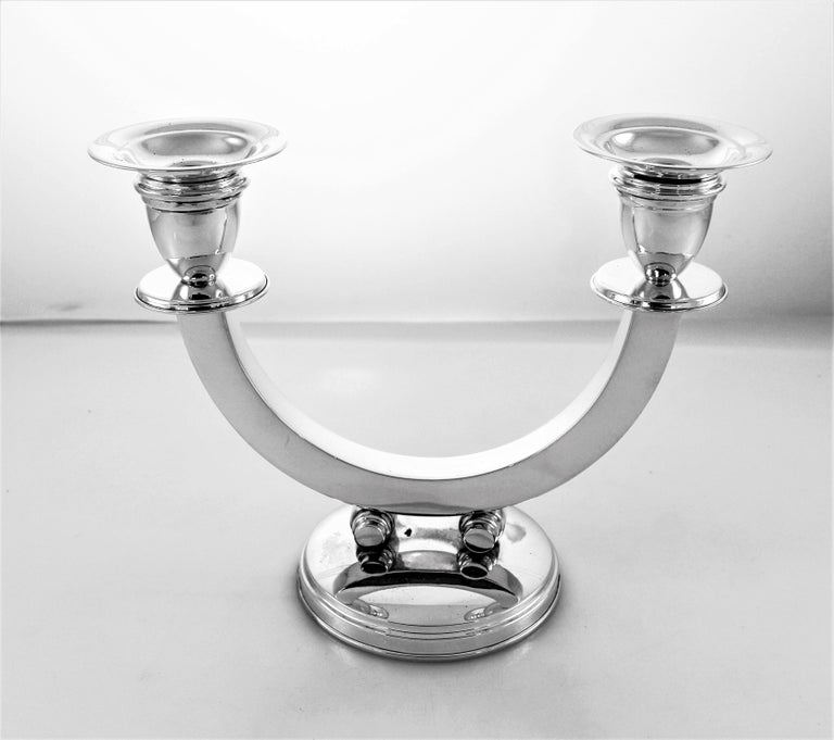 This pair of two-branch candelabras are probably the finest we have ever had; elegant, understated and very unique. A U-shaped piece holds both lights and stands on two balls just above the base. They are Uber-modern and are the quintessential