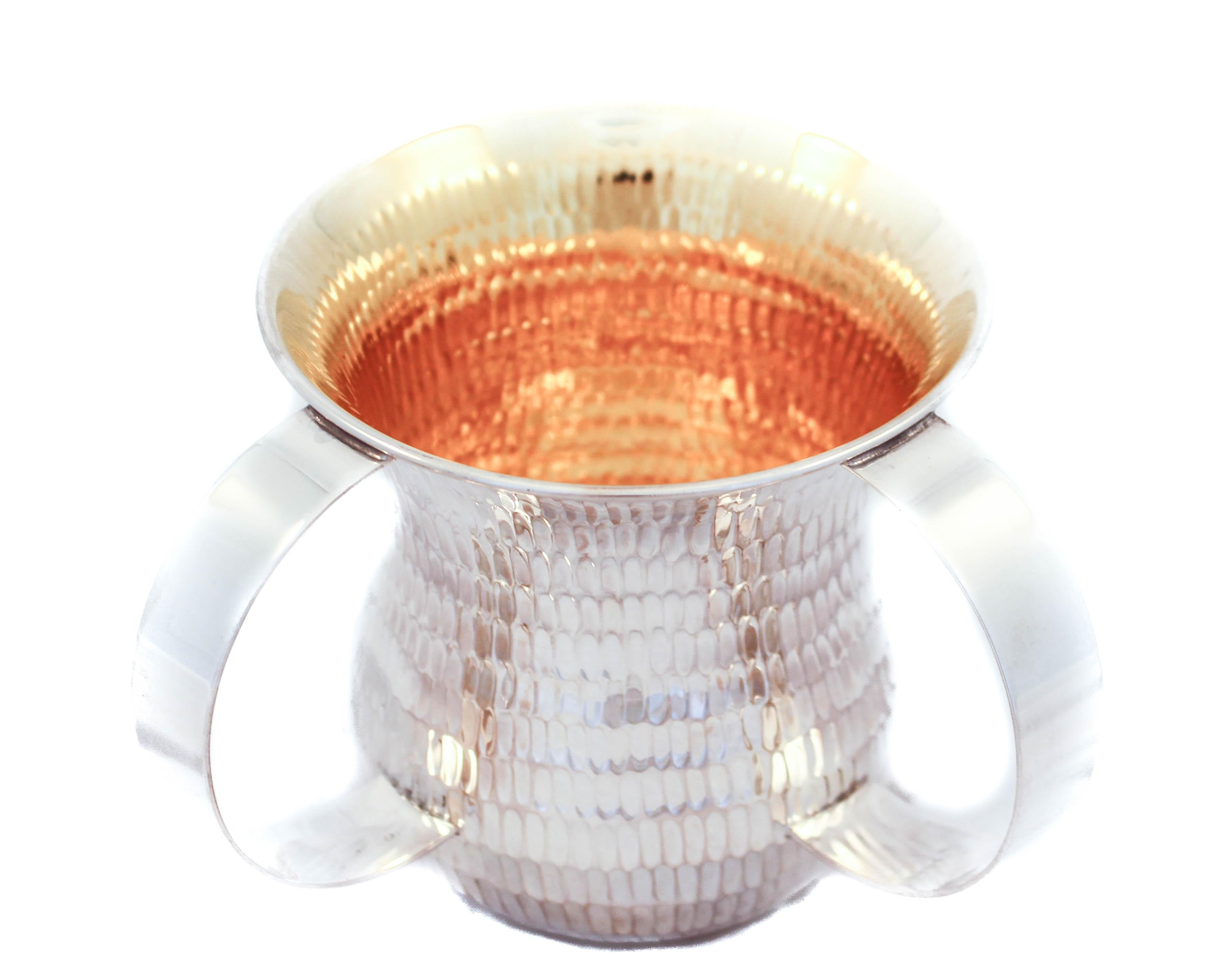 Being offered is a sterling silver washing cup (N’tillat Yadaiyim cup). This item is used to wash ones hands either before eating bread or performing religious requirements in the Jewish faith. 
It has a modern shape and design. Notice the curved