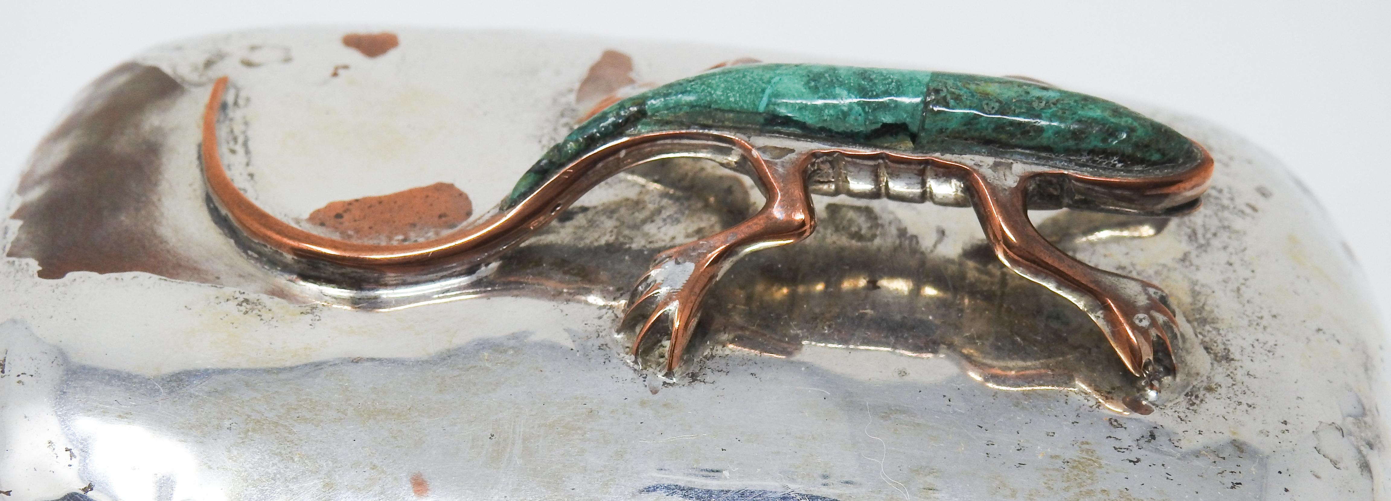 Offering this unique and gorgeous sterling plated lidded dish with a turquoise lizard sculpture on top. You can tell that the dish is handcrafted and hammered copper, and the sterling has been plated on top of the copper. It gives the dish and