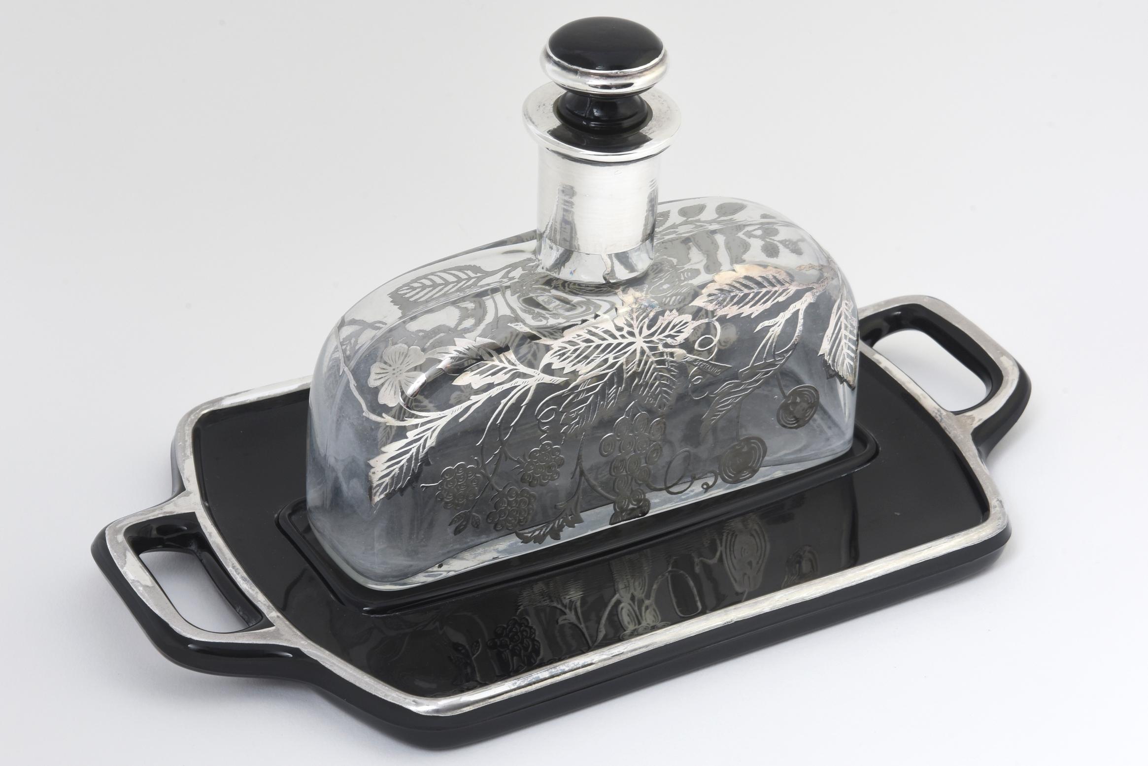 Large clear glass perfume bottle with sterling silver overlay. Tray and stopper are made from black glass with a sterling-silver border. Age wear, light white residue inside bottom. Marked 