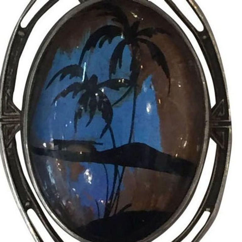 Beautiful pendant of a hand painted butterfly wing depicting a tropical scene in an Art Nouveau style sterling silver frame,
circa 1920s.
Hallmark reads, 