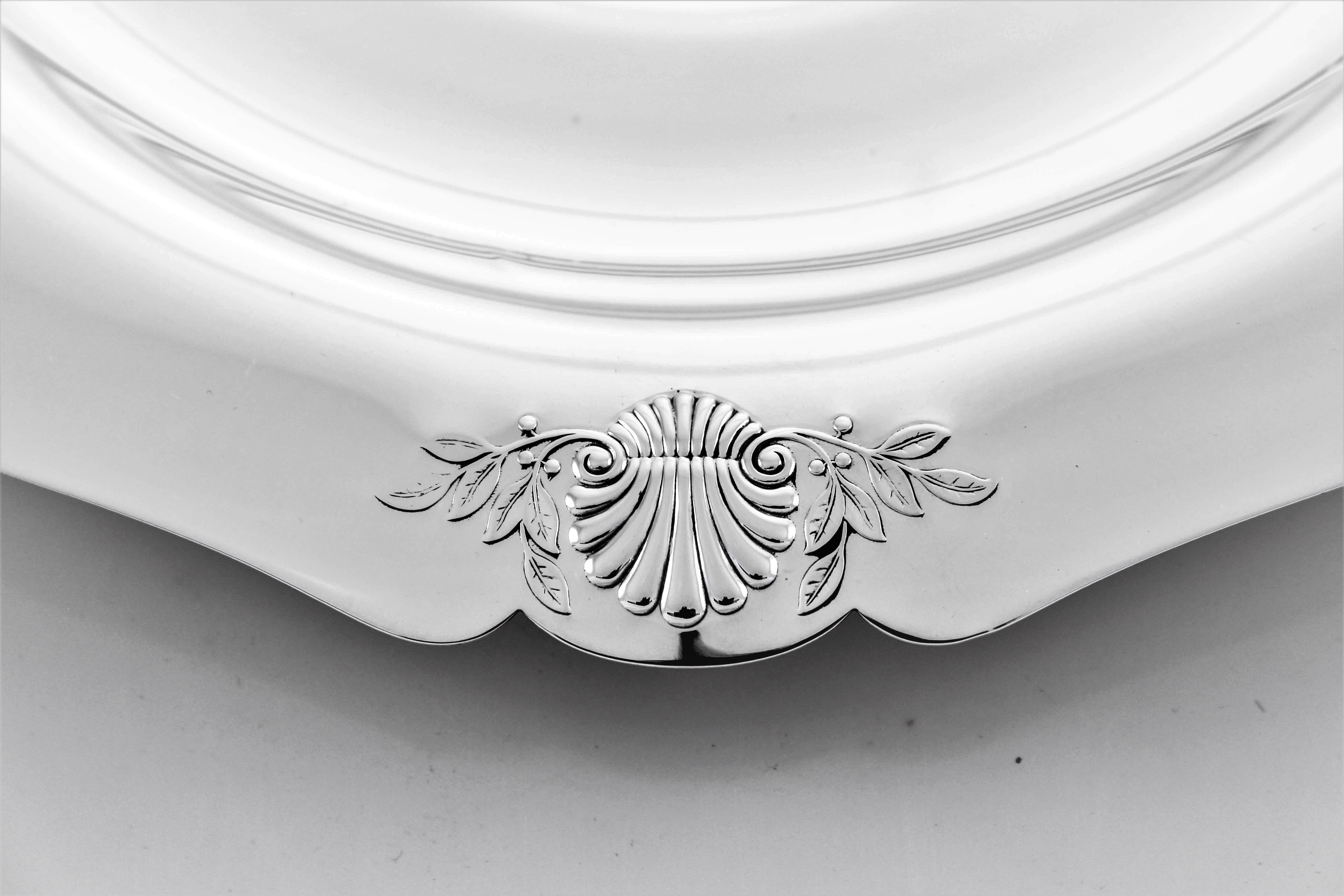 This plate has a scalloped edge and four shell designs surrounded by branches. It has a nice heavy feel and a clean modern look.
 