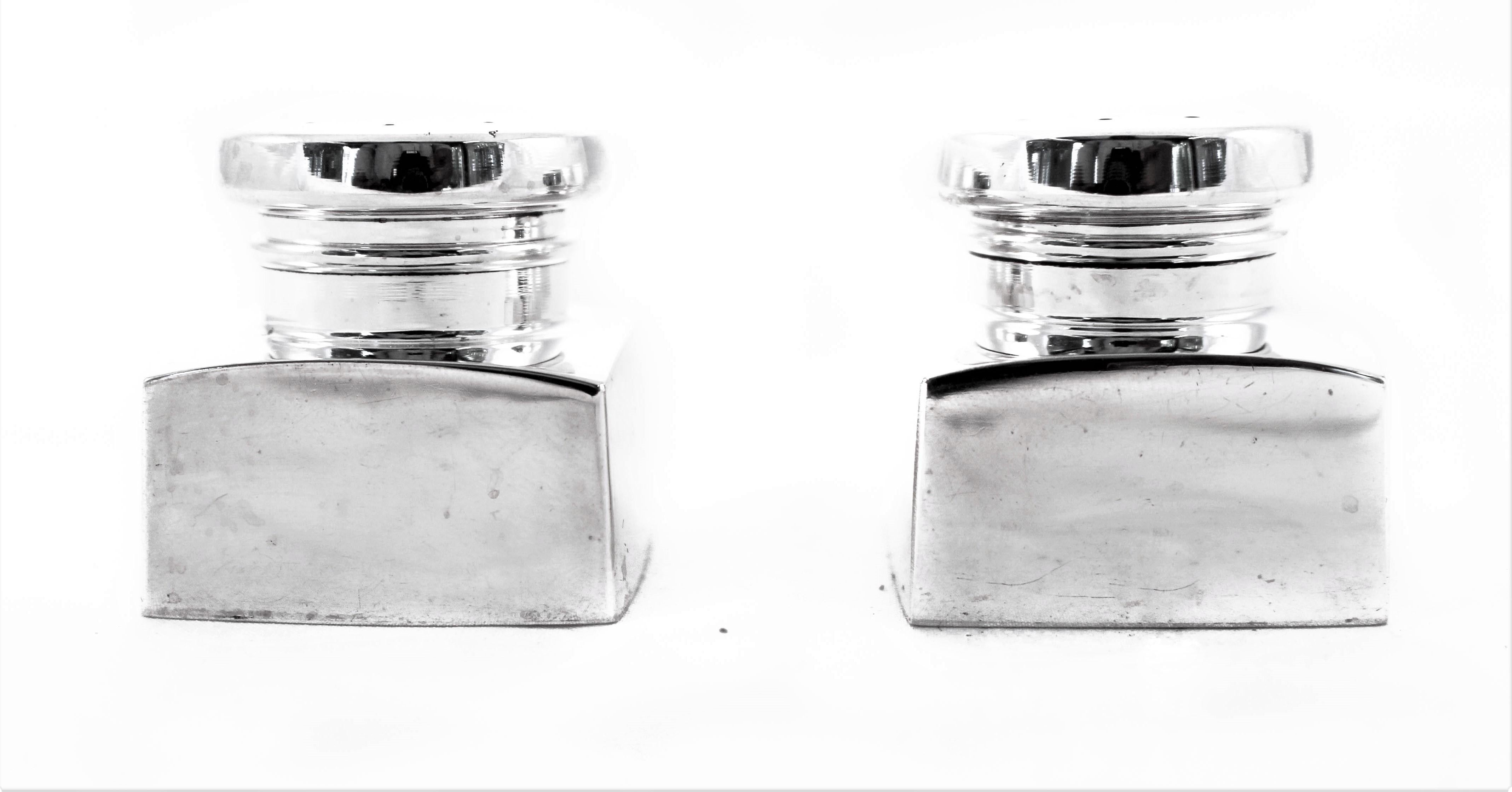 Uber-modern and uber-chic, this pair of salt and pepper shakers has that midcentury look that is so popular. A square shape body topped with a round cover. There are no etchings or decoration on them, just the clean look of sterling silver.
 