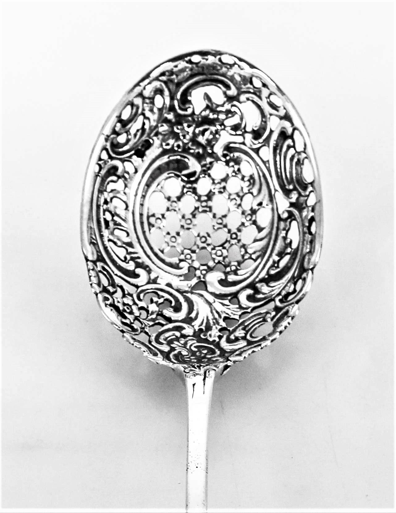 If you enjoy entertaining in style, you will love this super-large sterling silver pierced serving spoon. It has an extra long handle and delicate openwork on the end and bowl part of the spoon. Flowers and latticework work come together to form a