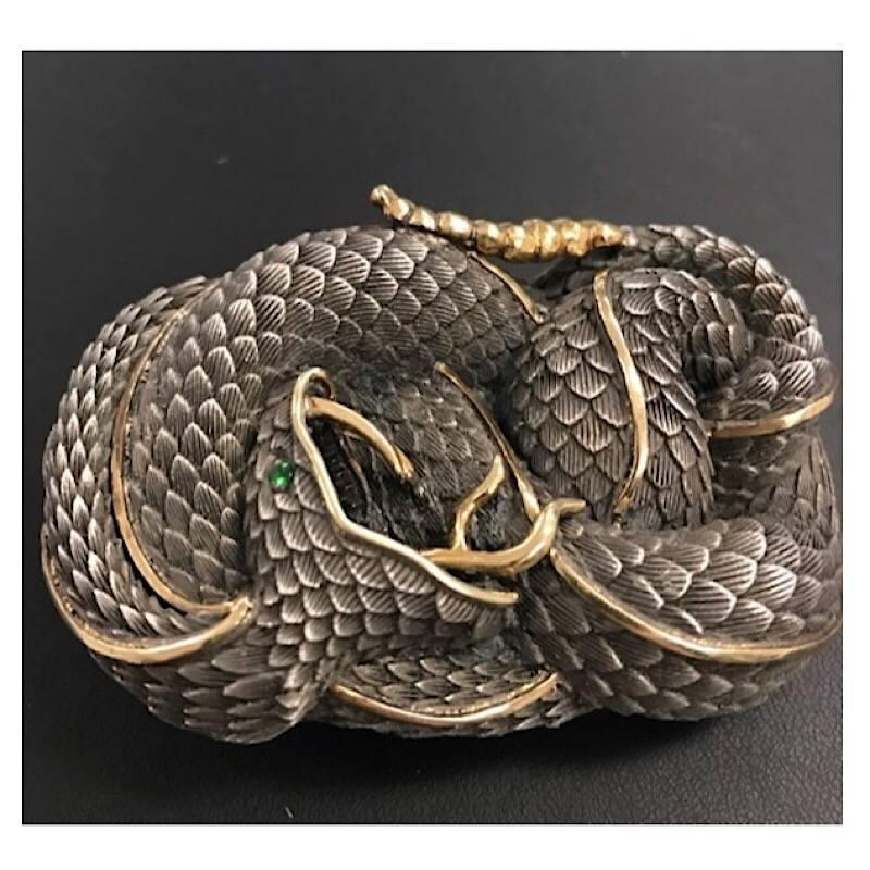 Sterling Silver & 22k Gold Snake Style Belt Buckle With Emerald Eye.

Sterling & 22k Gold Snake Custom belt buckle in the shape of a snake cast in Sterling Silver and detailed in 22k Gold.  Buckle is completely hand carved and hand engraved with a