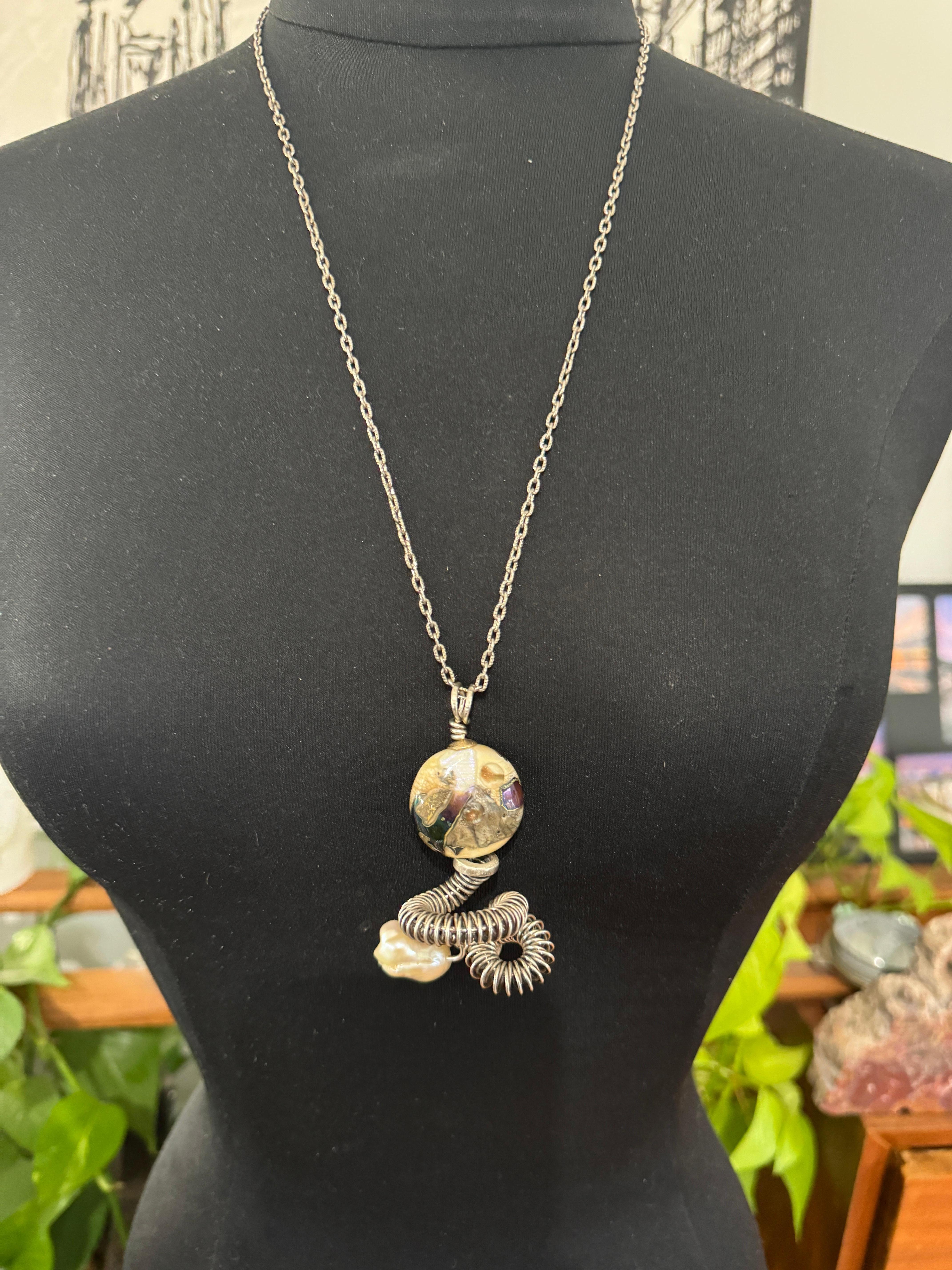 Ce collier Kathleen Dennison, fabriqué à la main, est orné de détails en argent sterling et en or 14 carats. Collier de grande taille avec des perles de verre et une grosse perle baroque au bas du collier.  Grande échelle. Sur un collier en argent