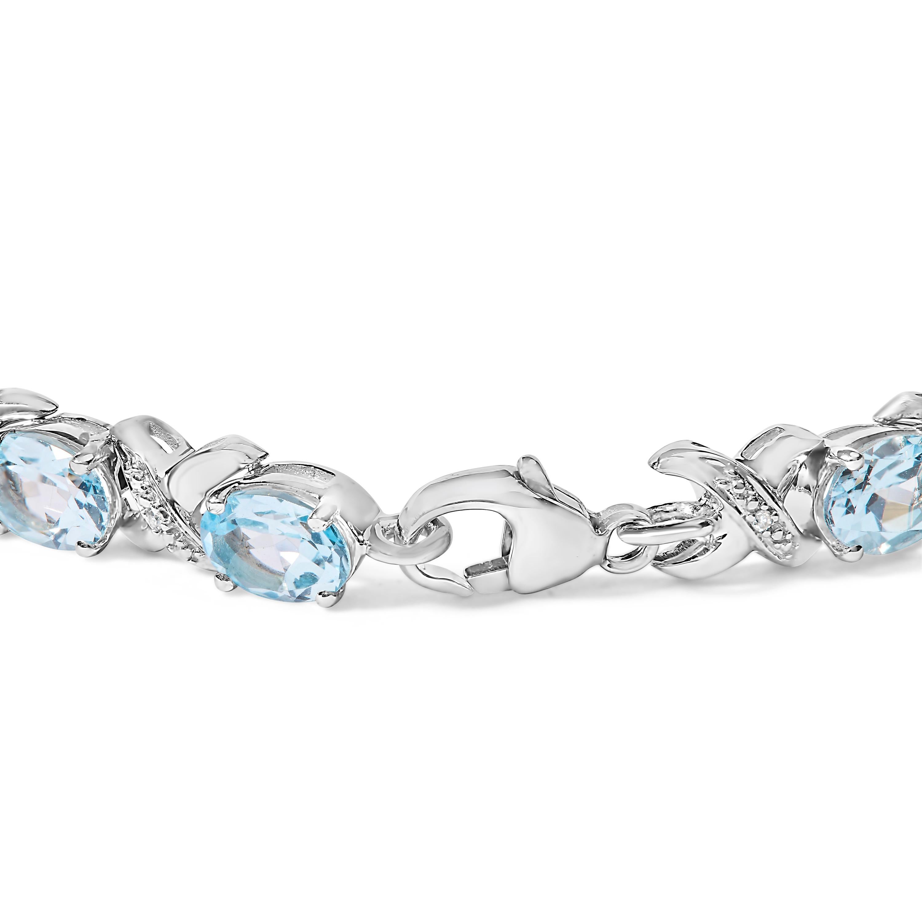 Embrace the epitome of elegance and sophisticated style with this enchanting .925 sterling silver bracelet, adorned with 16.0 carats of mesmerizing oval blue topaz gems and delicate diamond accents that sparkle with an I-J color and I1-I2 clarity.