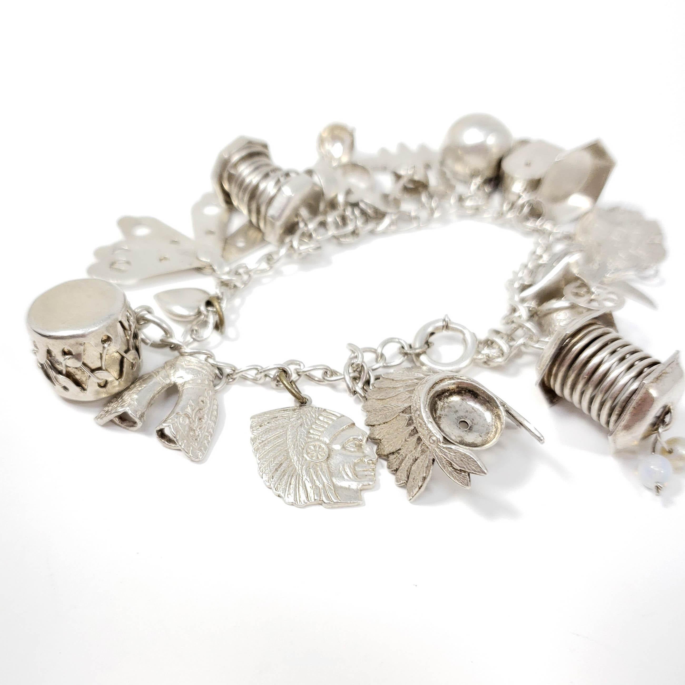 A sterling silver bracelet with an assortment of dangling charms!

Charms: drum, thimble, yarn spinning wheel, mailbox, plate, pliers, ball and chain, plane, weighing scales, cowboy chaps, heart, Native American chieftain, headdress, handcuffs,