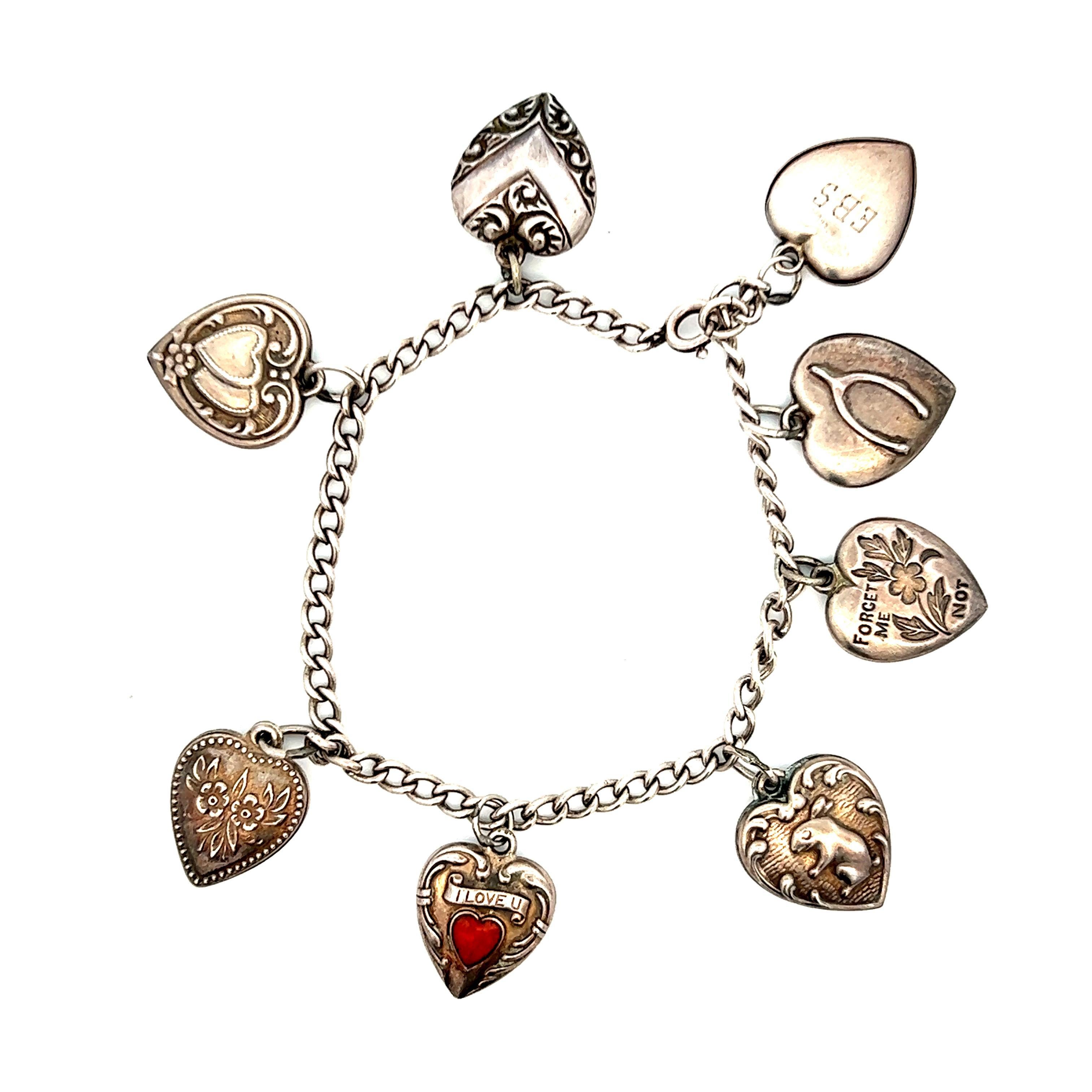 This is an exquisite sterling silver charm bracelet, a timeless piece crafted from high quality sterling silver, coming from the 1940s Art Deco period. This stunning bracelet features an array of charming vintage inspired charms, each designed to