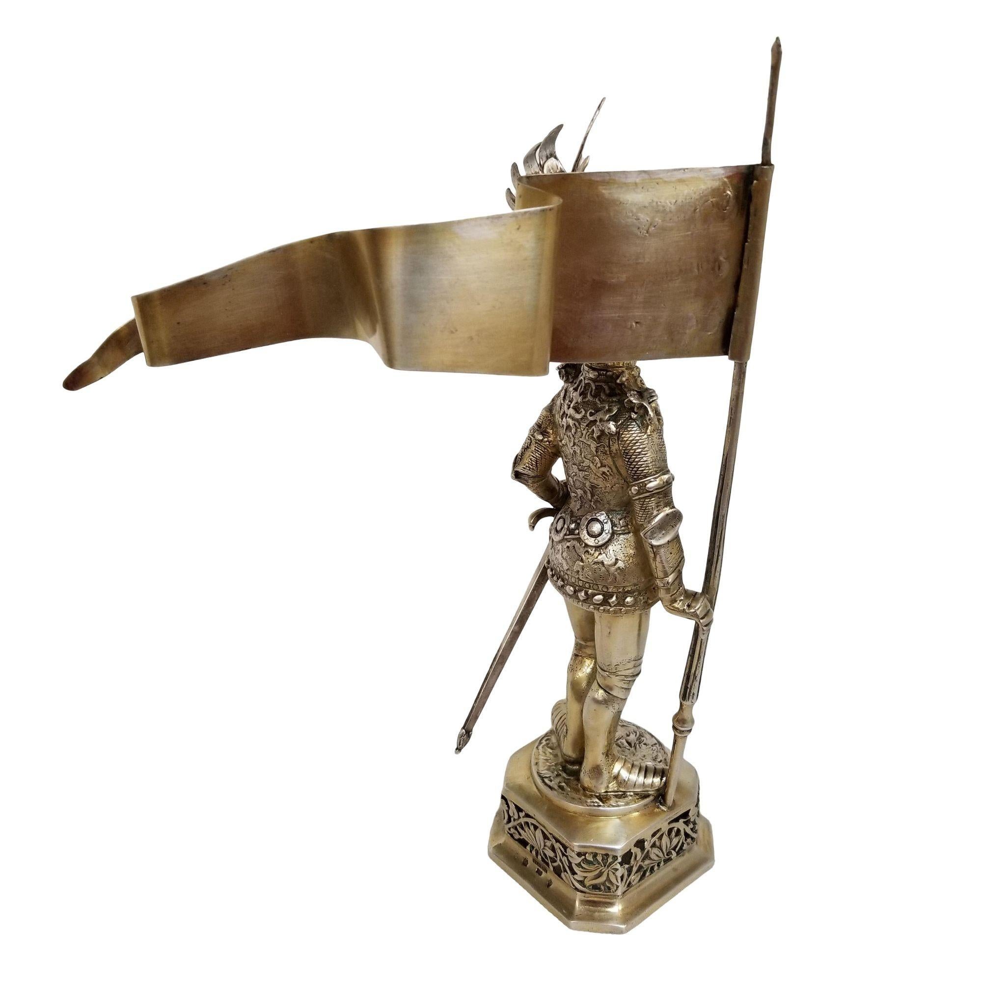 Cette figurine de chevalier en argent sterling datant du XIXe siècle est un chef-d'œuvre captivant. Vêtus d'une armure médiévale complète avec un bâton et un drapeau, les visières mobiles et les armoiries gravées de manière complexe témoignent d'un