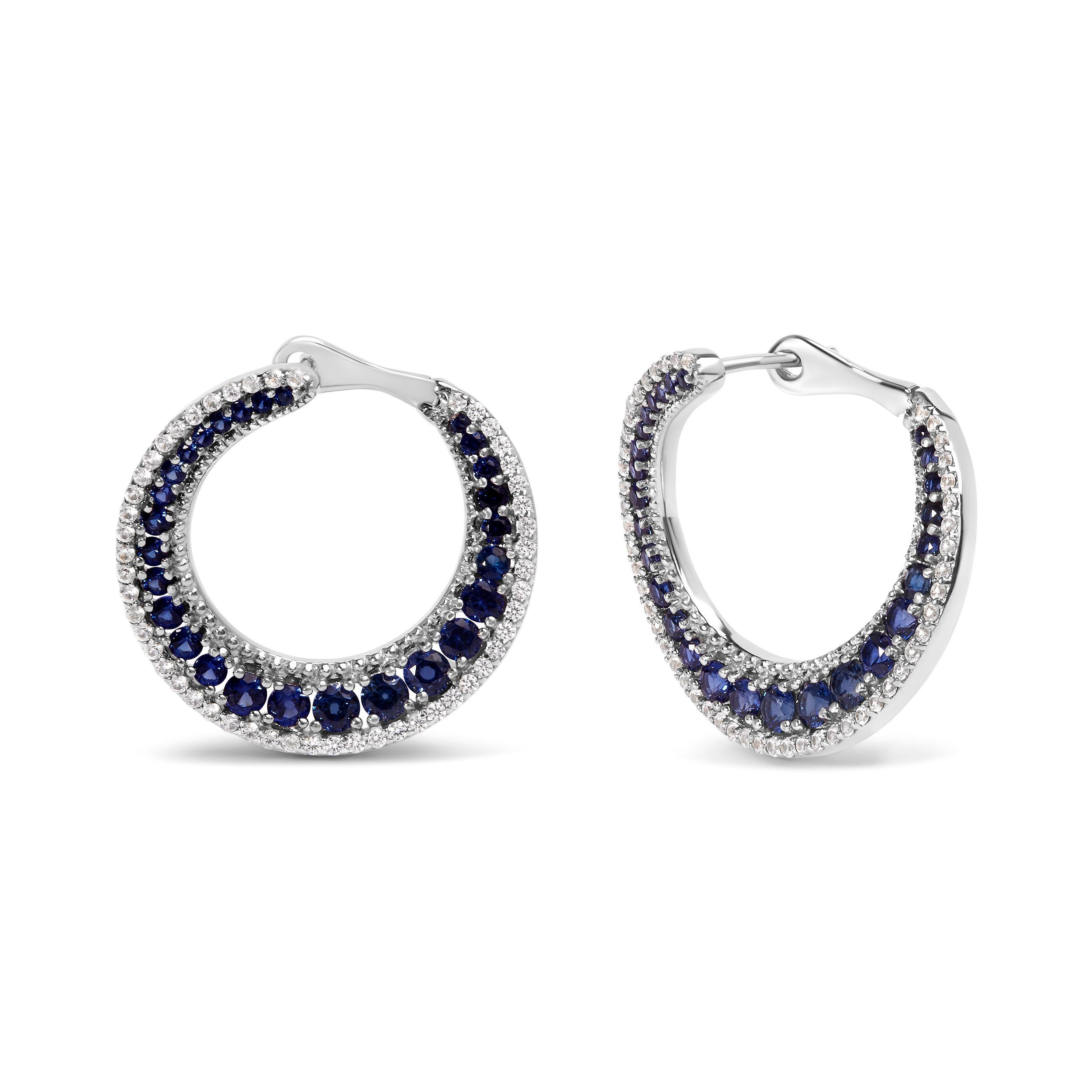 Introducing a celestial masterpiece that will make you shine like the moonlit sky! These exquisite .925 Sterling Silver Hoop Earrings are adorned with a mesmerizing array of 156 round Lab Created Blue Sapphires. Each gemstone is carefully set in a