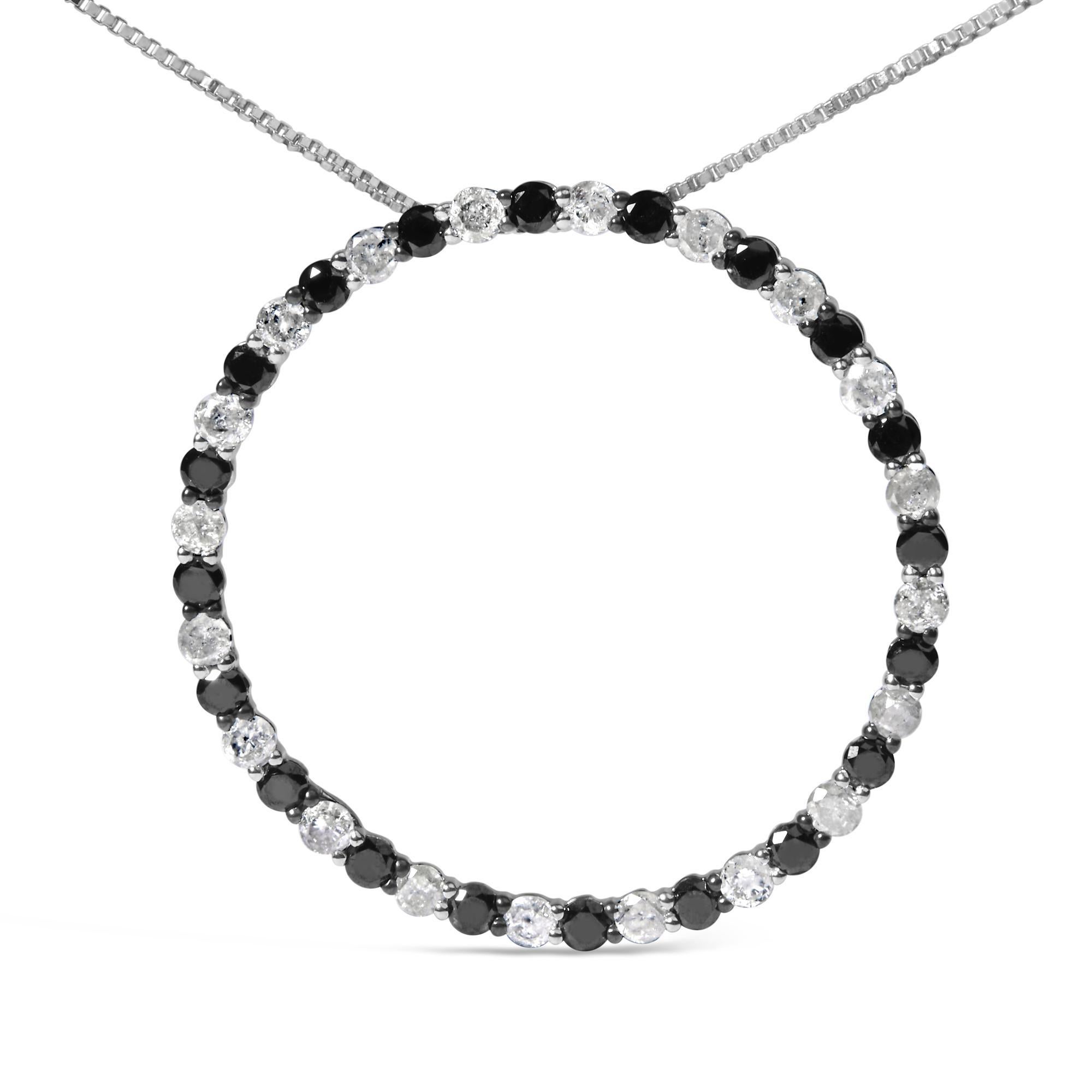 Realizzata con maestria in argento 925, questa collana con ciondolo è una masterclass in eleganza e contrasto. Il pendente a forma di cerchio è caratterizzato da un'affascinante disposizione di diamanti neri e bianchi a taglio rotondo alternati, per