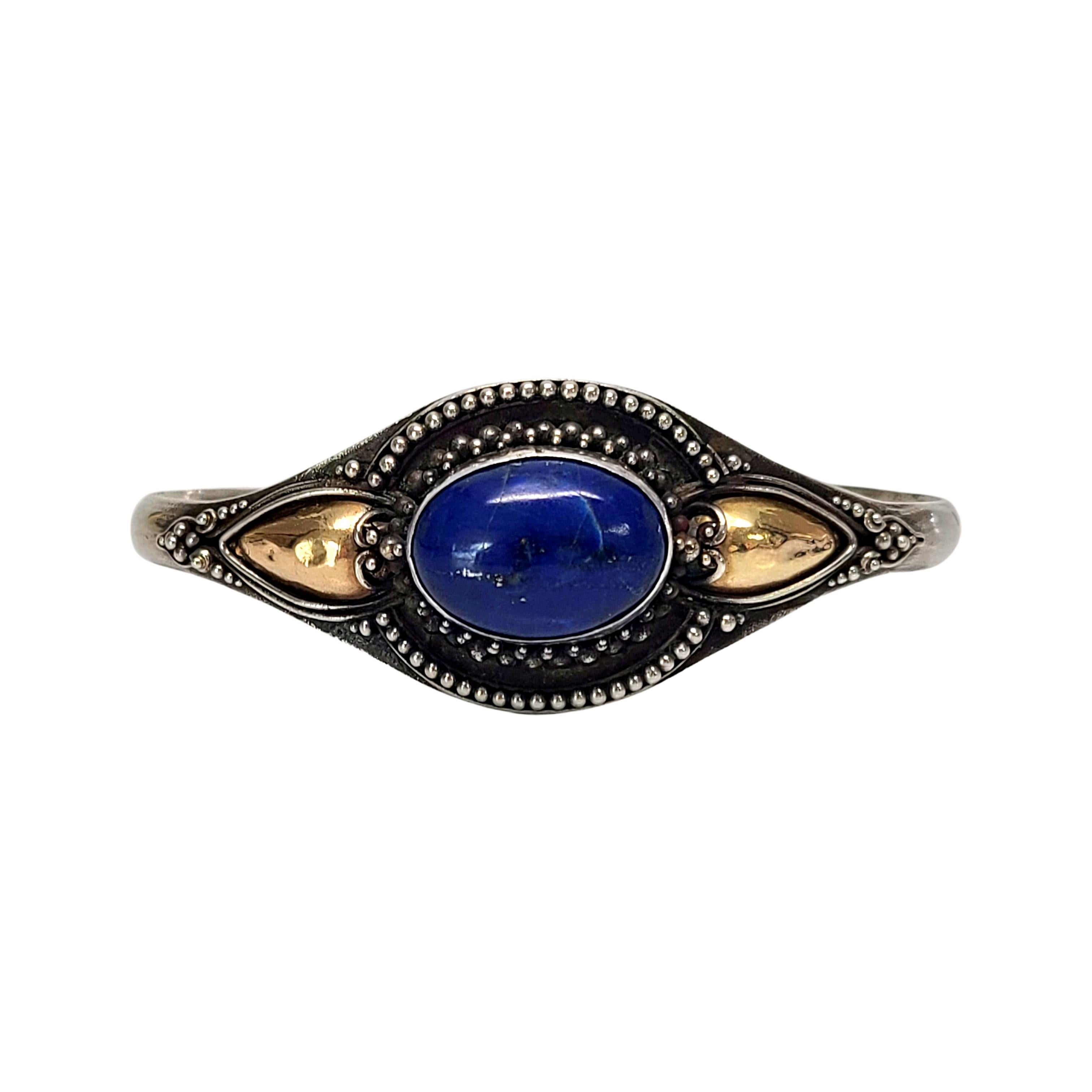 Sterling silver, 22K yellow gold accent and lapis lazuli bracelet.

Oval shaped bezel set lapis lazuli stone set in sterling silver with yellow gold dome accent on each side.

Measures approx 5 5/8