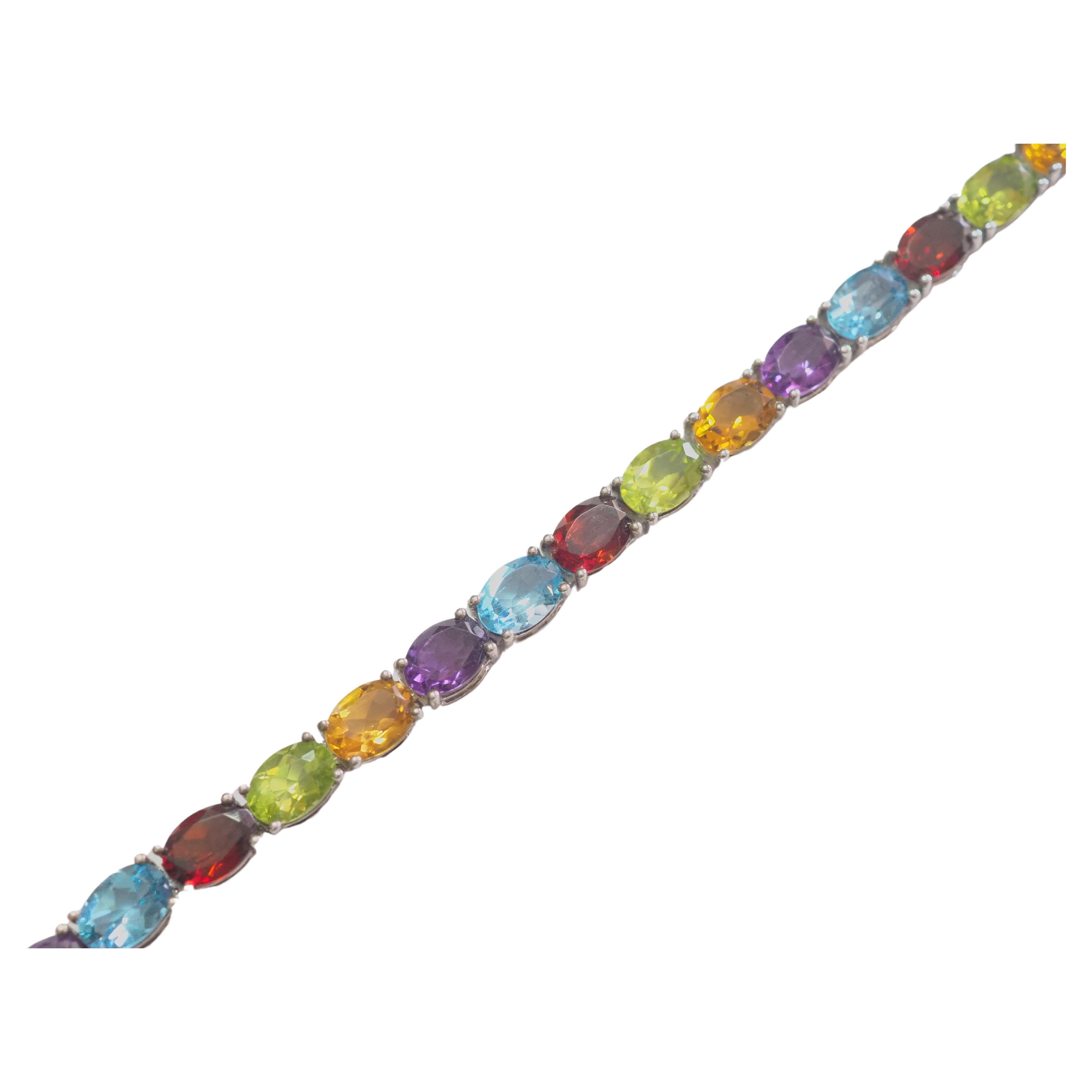 A very beautiful tennis bracelet in solid 925 sterling silver with a total of 25 gemstones ranging from oval yellow citrine, purple amethyst, sky blue topaz, green peridot and deep red garnet all natural oval gemstones. A very fine bracelet made