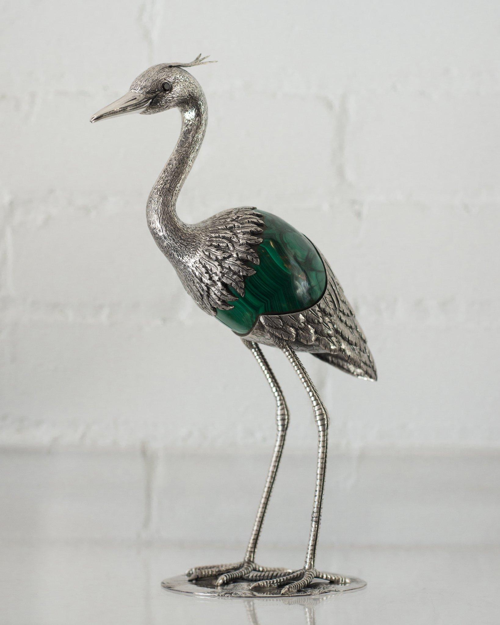 A 925 sterling silver heron sculpture with a malachite egg and red stone set eyes. Expertly crafted by a master jeweller in Porto, Portugal. This stunning bird is a decorative combination of ornithology and geology.