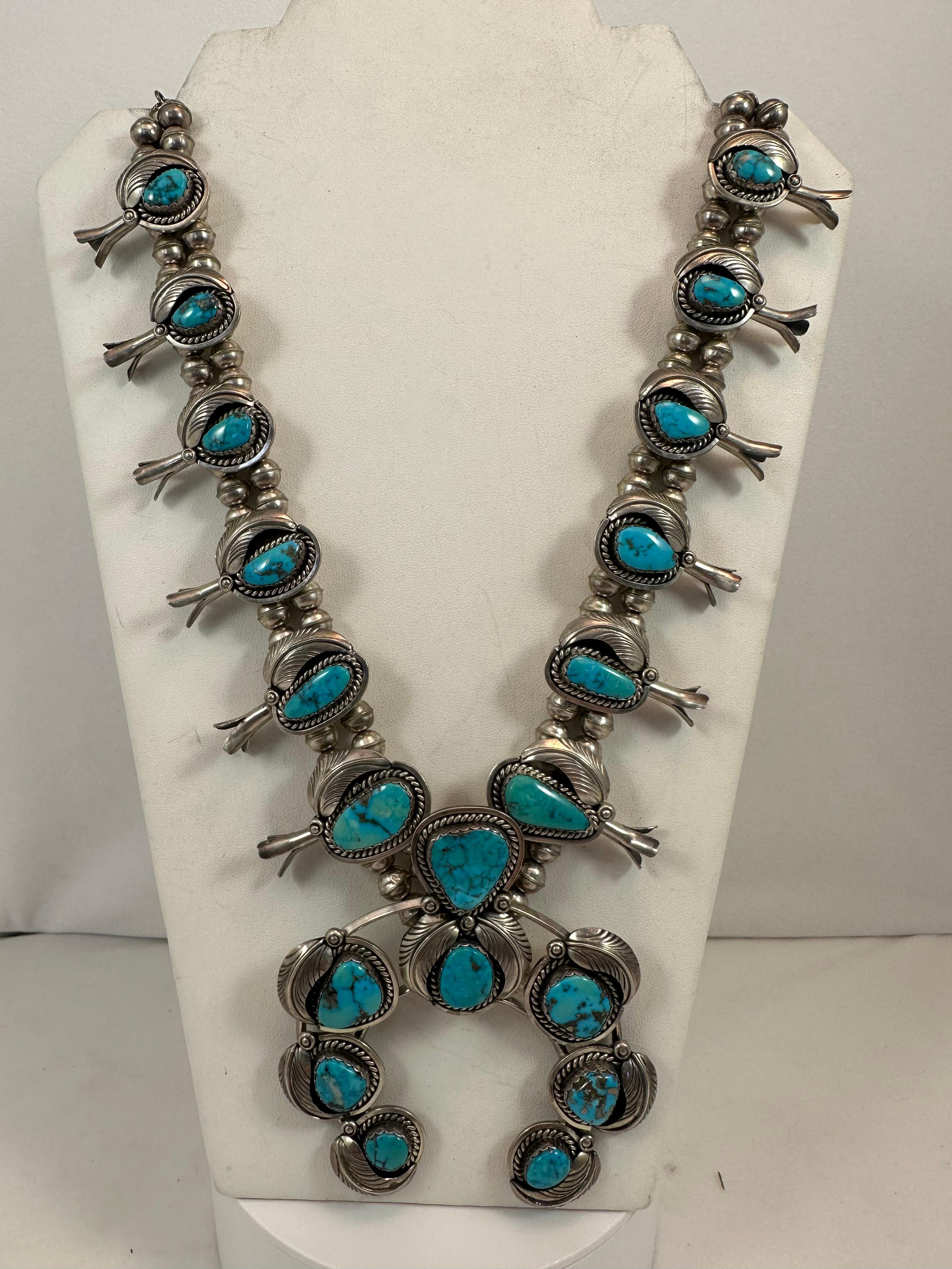 OLD PAWN
Handmade by Navajo Artist Don Platero ~ Sterling Silver .925 ~ 122 carats of Morenci Turquoise Squash Blossom. 
The Squash Blossom measures approx. length 32