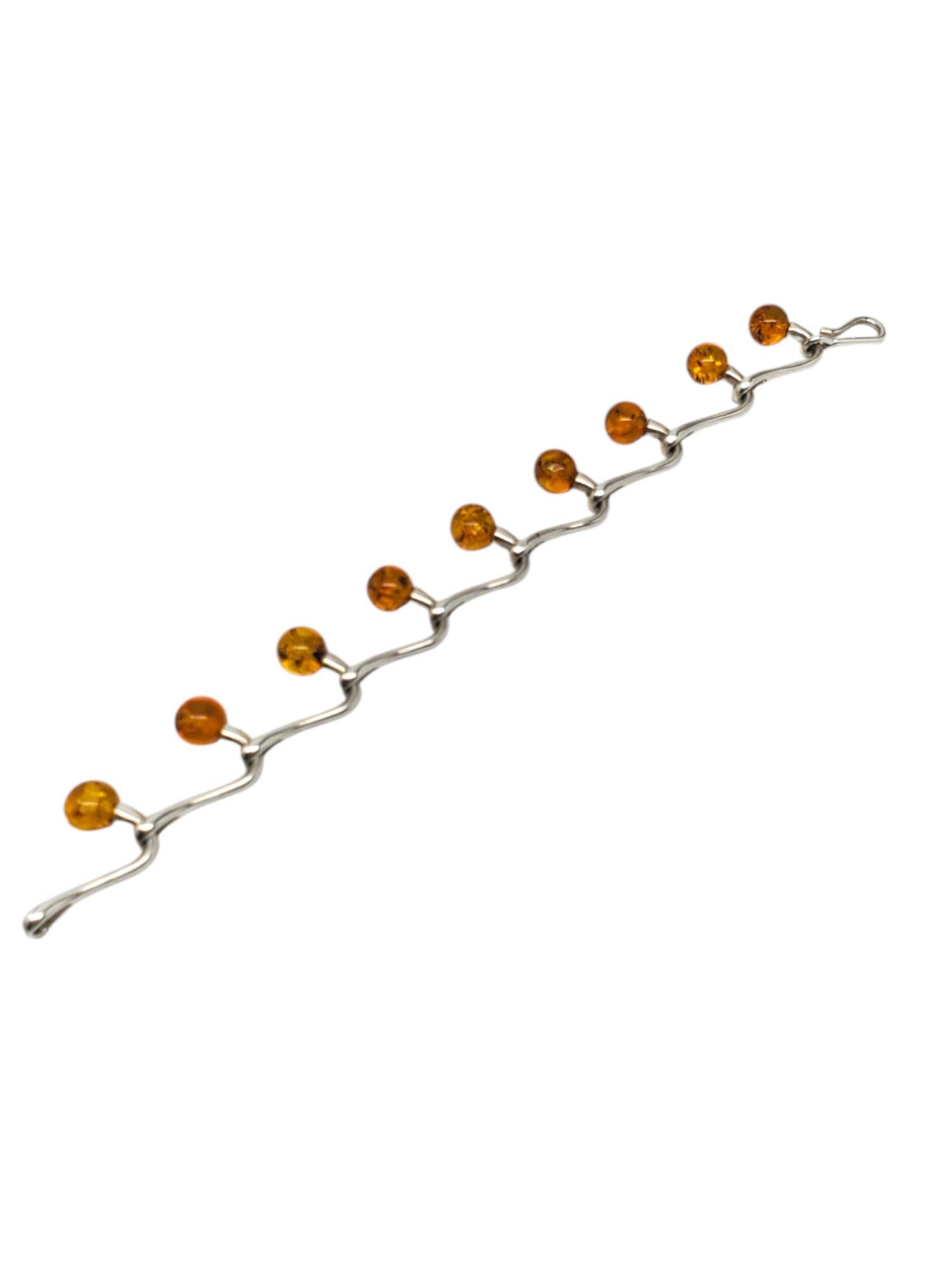 Sterling Silver Amber Beads Link Bracelet-

This dainty link bracelet is decorated with 9 amber polished beads in sterling silver with a hook & eye clasp.

Size: 7.5 in. in length

Approx. 17mm at widest 

Stamped: 925

Weigh: 10.7 dwt / 16.77