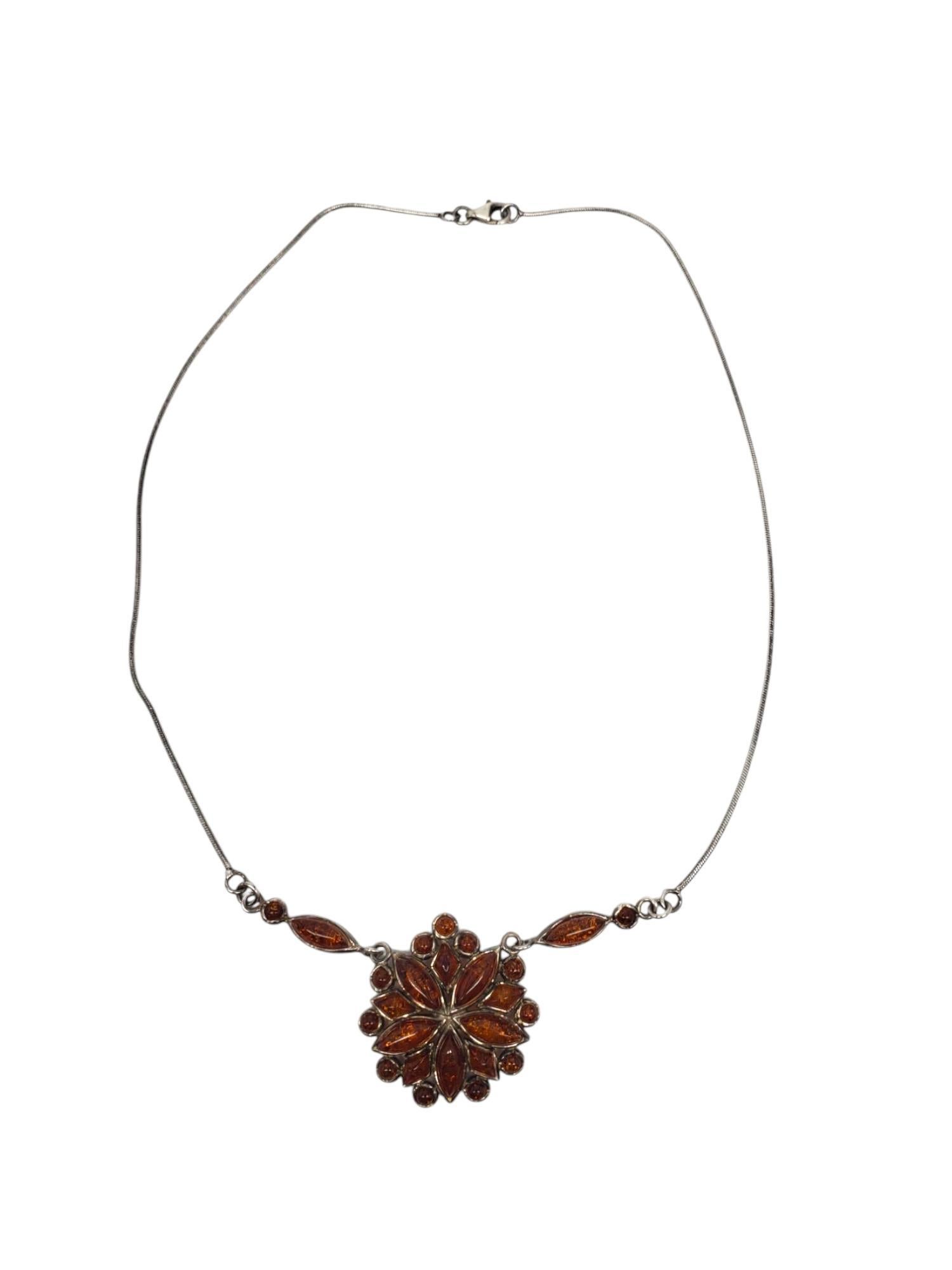 Sterling Silver Amber Floral Pendant Necklace -

This vintage necklace features a floral inspired pendant set with multiple amber stones in classic sterling silver with a lobster clasp.

Size : approx. 17