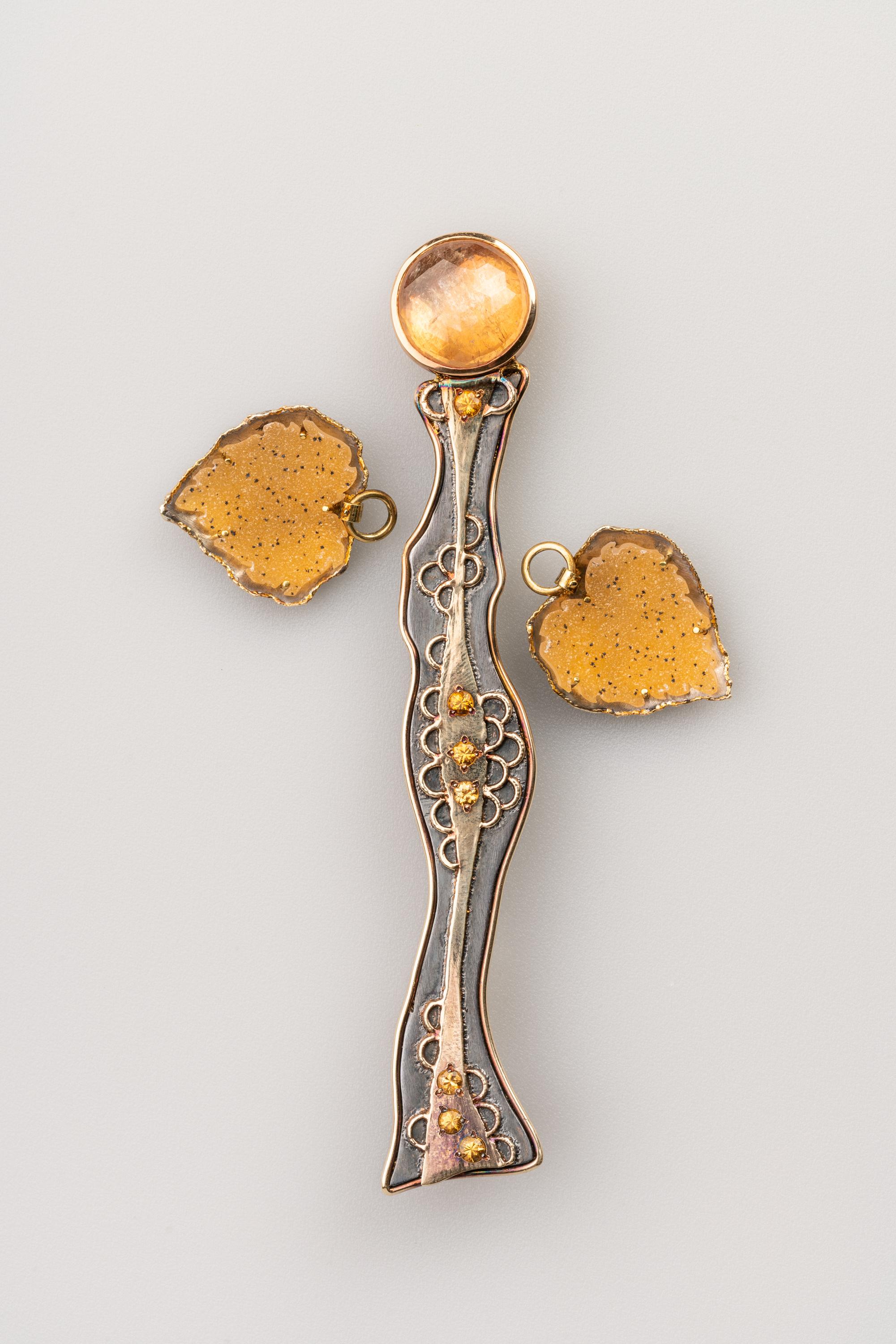Katiana is a sterling silver and 18k yellow, rose, and white gold Modullyn brooch and pendant, set with 1.13 total carat weight of spessartite garnets and a 9.15 carat rose cut peach sapphire.  Her yellow druzy wings detach and can be worn as