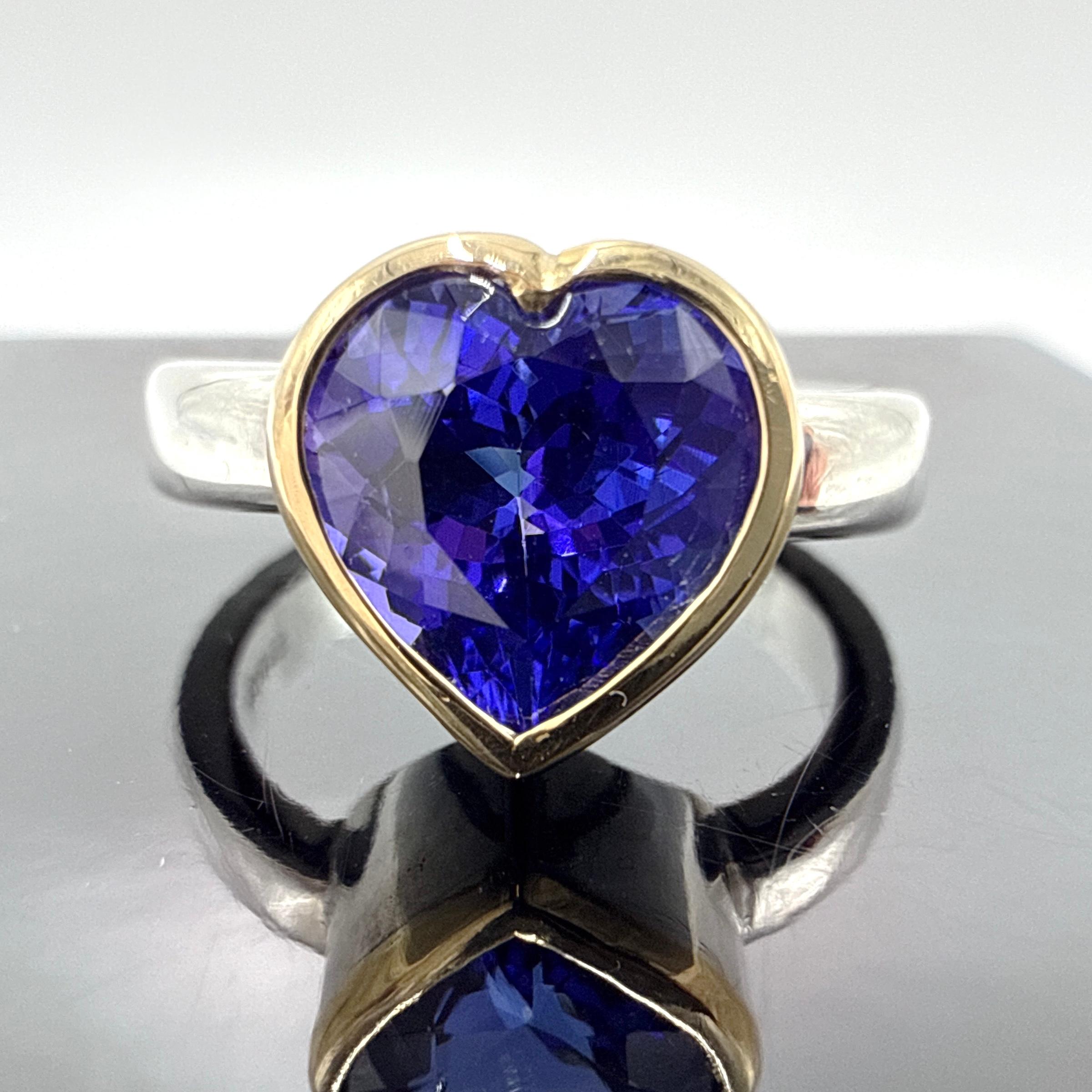 Bague pour femme faite à la main en argent sterling avec chaton en or jaune 18K, sertie d'une tanzanite de 3,35 carats taillée en cœur. La bague présente un chaton vertical entre des épaules rectangulaires arrondies, avec un dessous ouvert et une