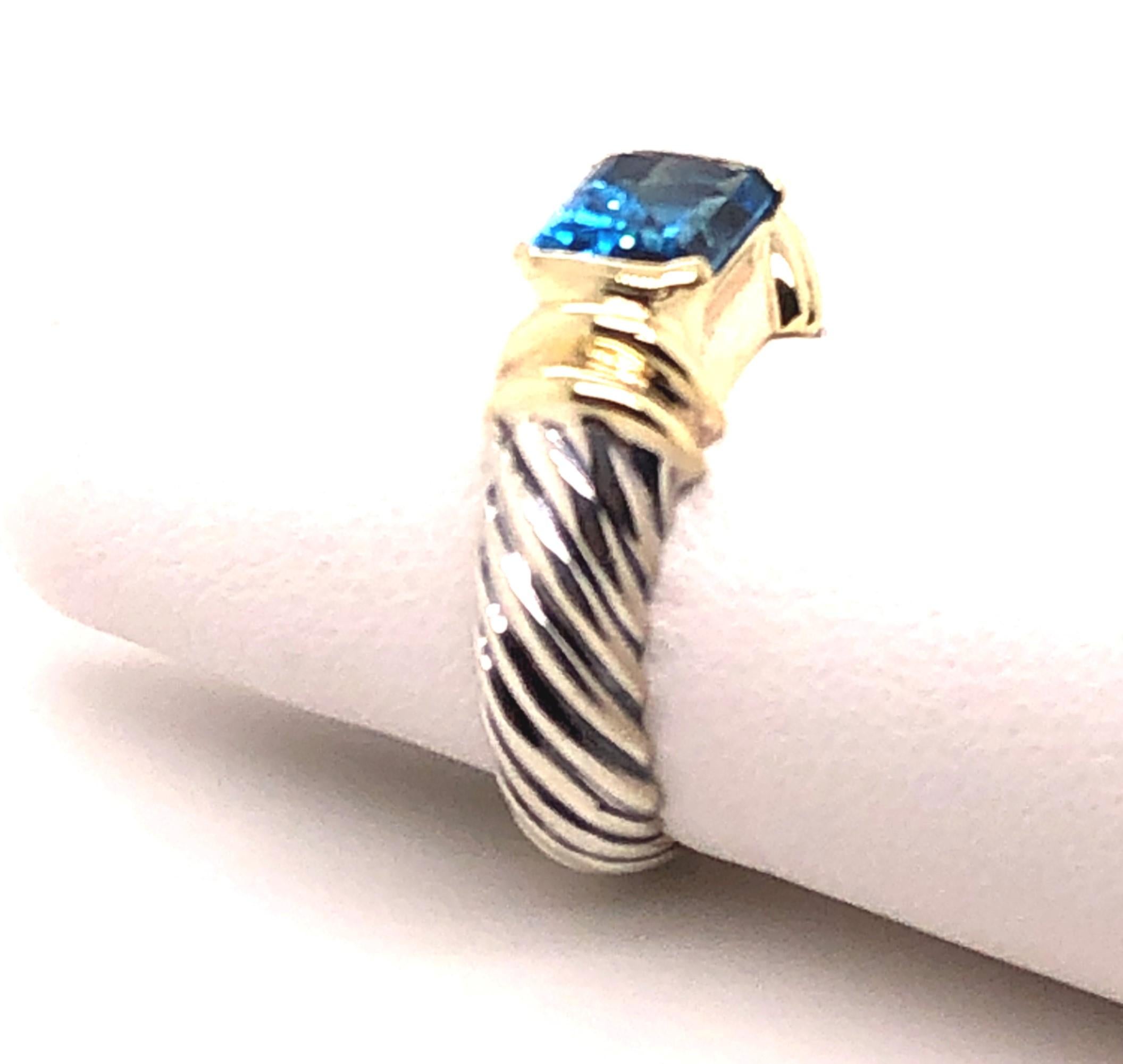 Sterling Silver with 18kt yellow gold details set off the sides and bezel of this ring. The 18kt gold holds a rectangular cut London Blue Topaz in the center. The finger size of this ring is a 6, but it can be sized to fit your finger. The inside is
