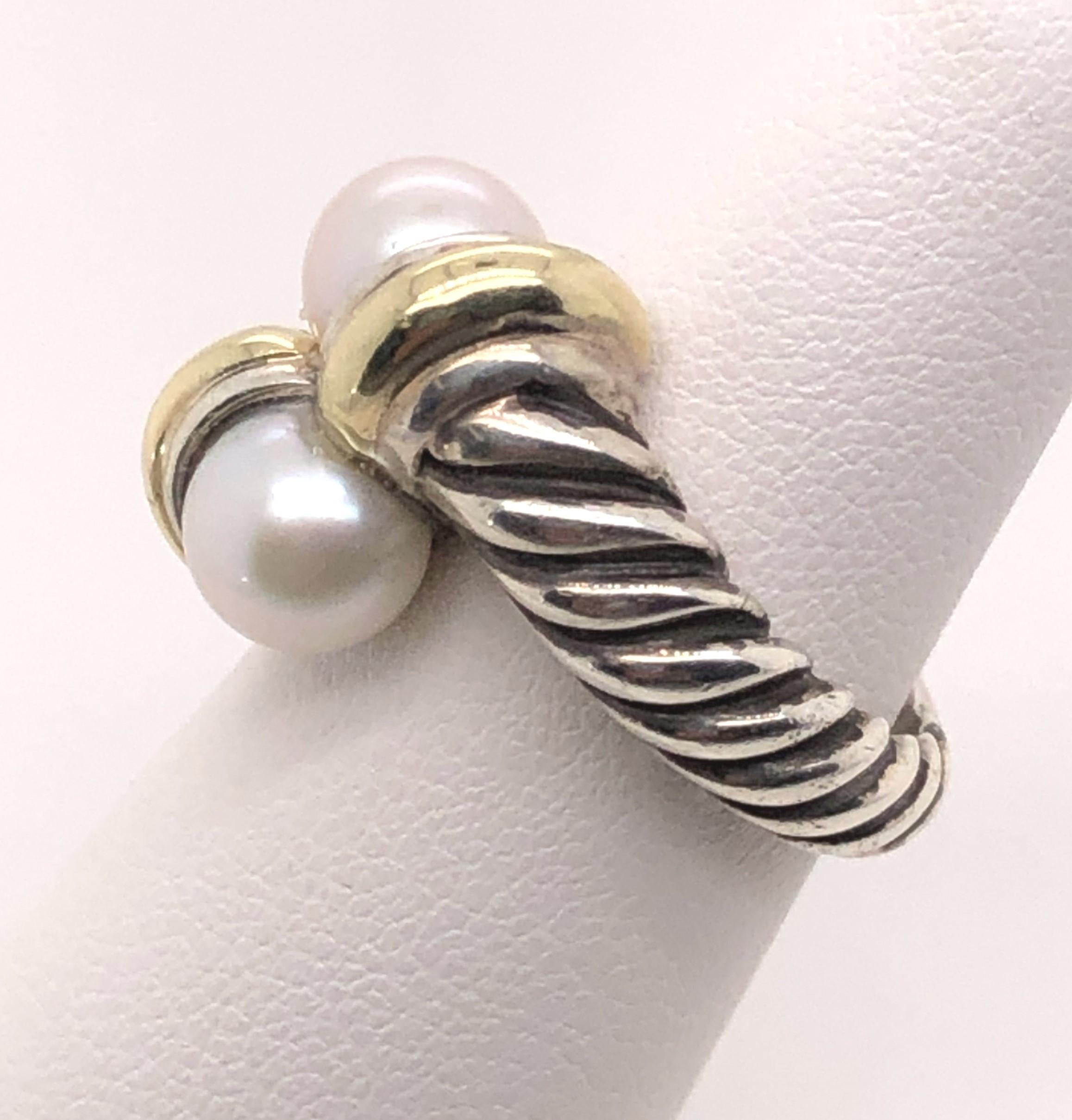 This sterling silver and 18kt yellow gold David Yurman ring contains two twin round white pearls set in a bypass style. The ring is a finger size 6 and can be sized to any finger size. The inside is stamped with David Yurman's DY stamp and 925/ 18k.