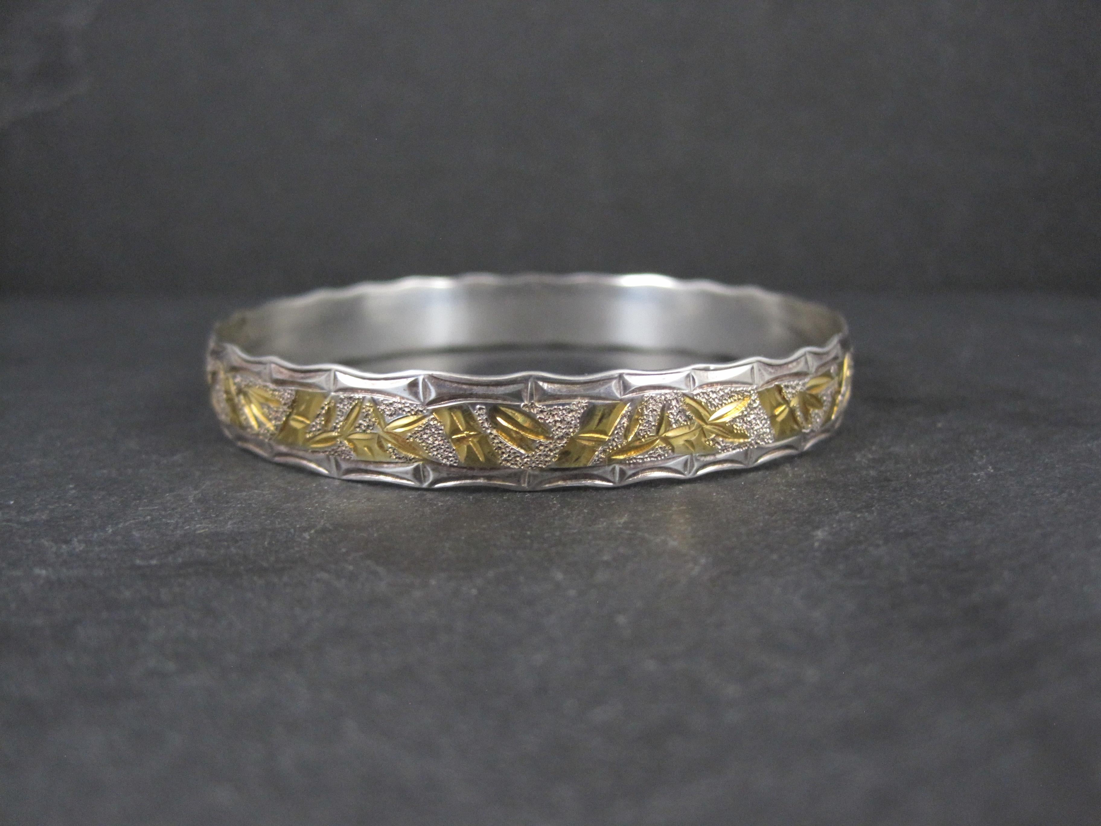 This beautiful vintage bangle bracelet is sterling silver.
Its bamboo design is accented in 8k yellow gold.
This bracelet measures 10mm wide.
It has an inner circumference of 7 1/2 inches and an inner diameter of 2 1/4 inches.
Weight: 19.4